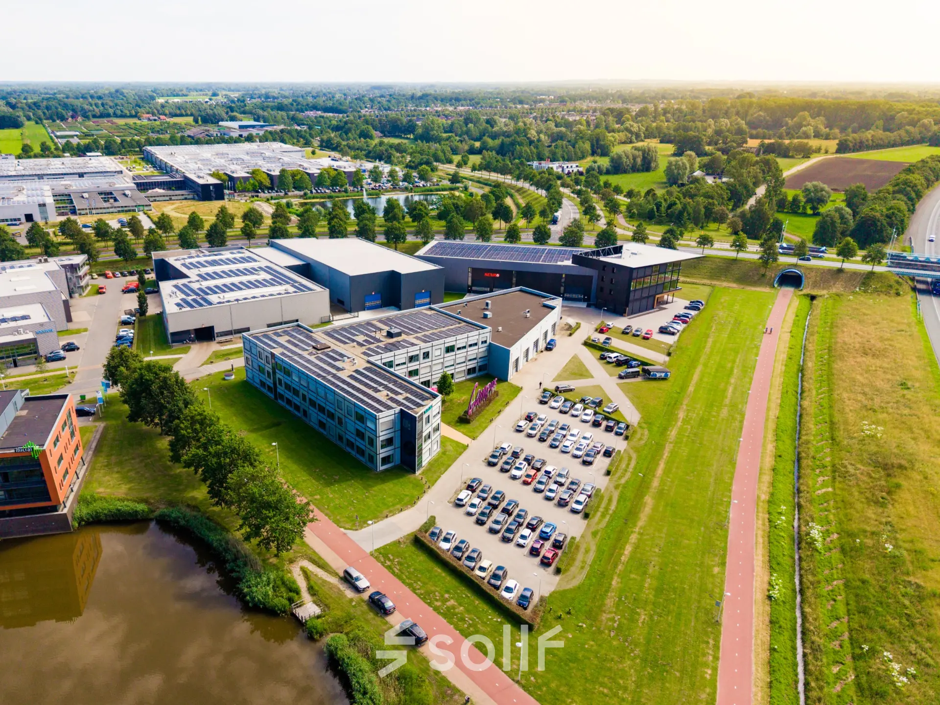 Aerial view of office complex at Jan Tinbergenstraat 202, Hengelo, featuring surrounding green spaces and parking. Ideal for office space rental.