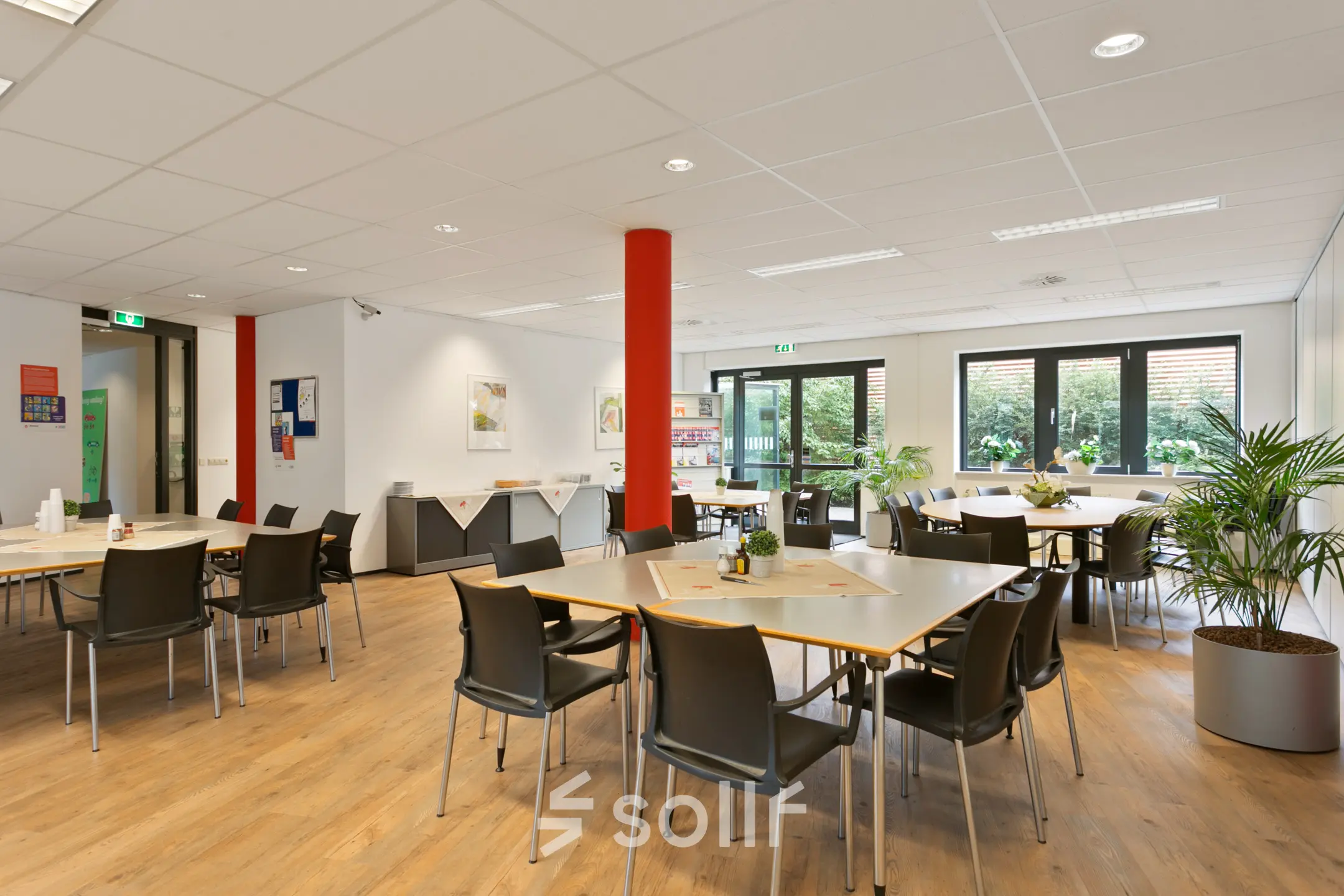 Bright office space at Welbergweg 60 in Hengelo featuring wooden floors, tables, chairs, and potted plants, ideal for office space rental.