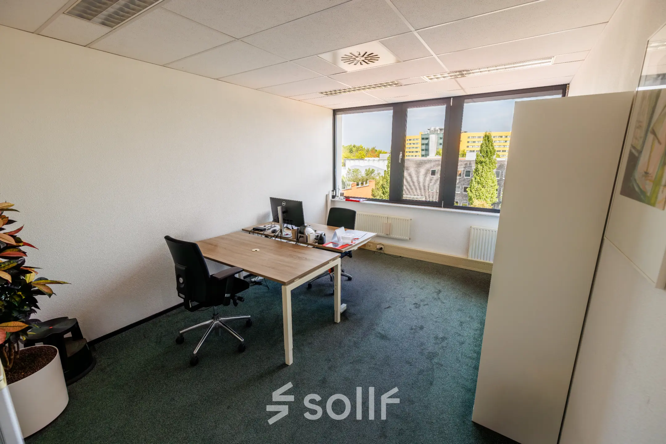 Bright office space at Welbergweg 60 in Hengelo with large window, furnished with desks and chairs, ideal for those looking for an office to rent.