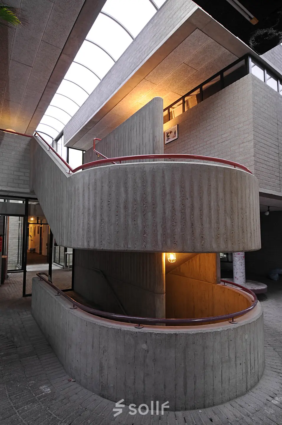 Interior view showcasing a unique concrete staircase with open lighting at an office to rent in Hilversum.