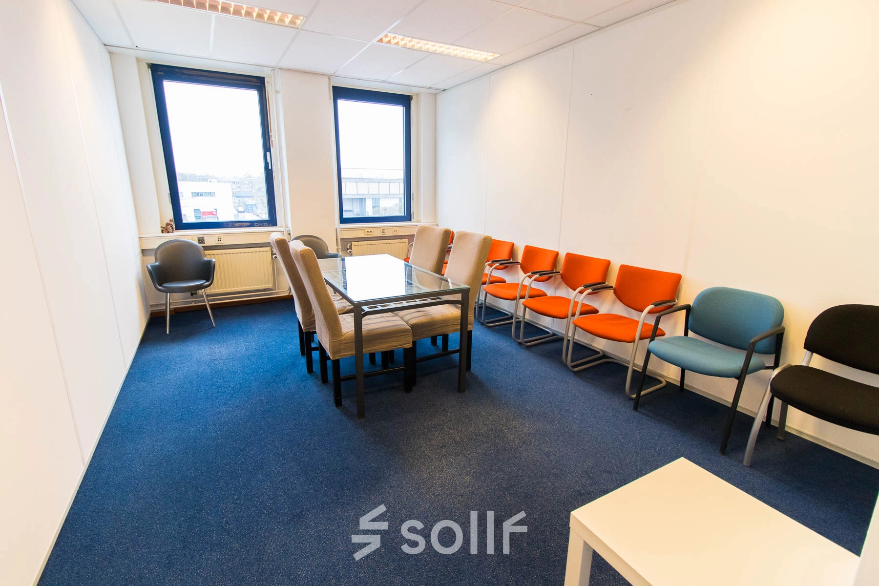 Office space rental at Franciscusweg 219, Hilversum. The room features a table with chairs, perfect for meetings or collaborative work. Large windows provide ample natural light, illuminating the office to rent.