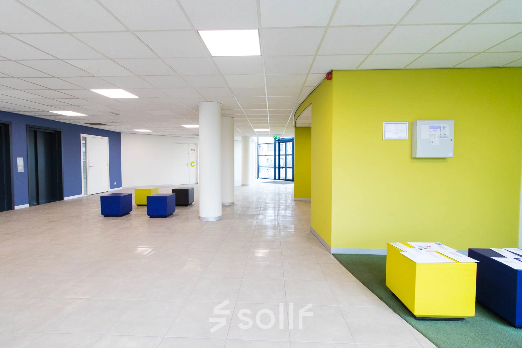 Spacious and bright entrance area at Franciscusweg 219 in Hilversum with colorful seating, ideal for office space rental.