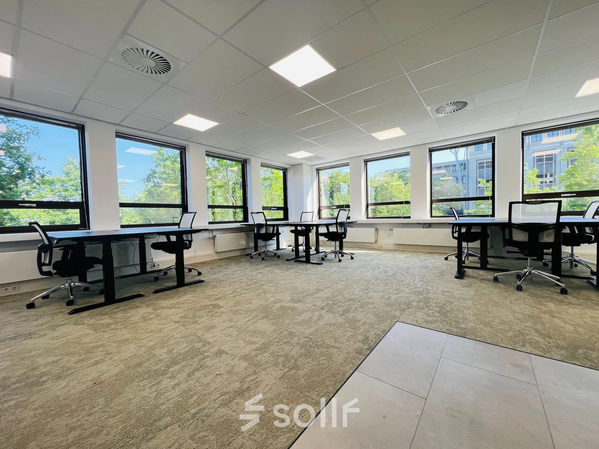 Spacious office to rent at Marathon 2, Hilversum, featuring large windows, several desks, and ergonomic chairs for optimal office space rental.