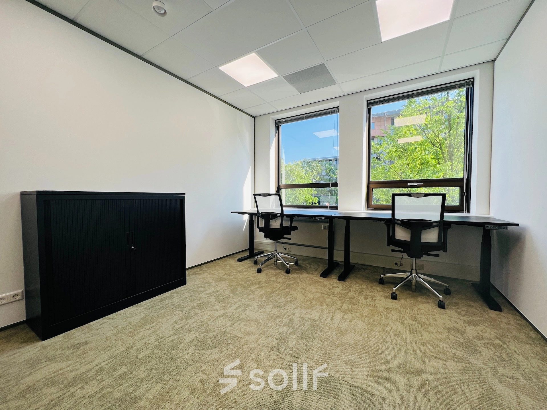 Bright office space at Marathon 2, Hilversum, featuring two desks with office chairs and a cabinet, ideal for office space rental.