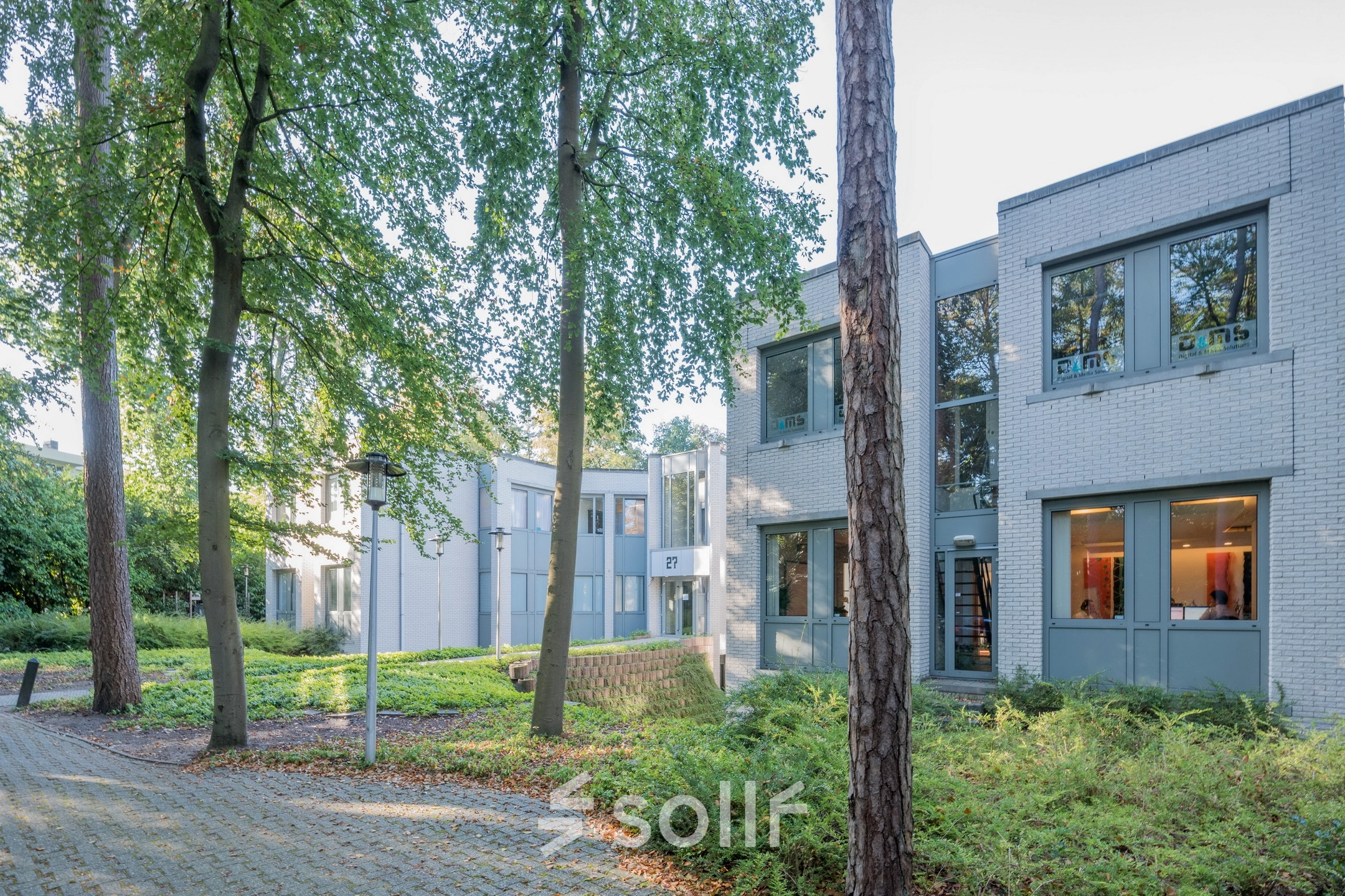 Exterior view of an office building at Mozartlaan 27, Hilversum, surrounded by trees, perfect for office space rental.