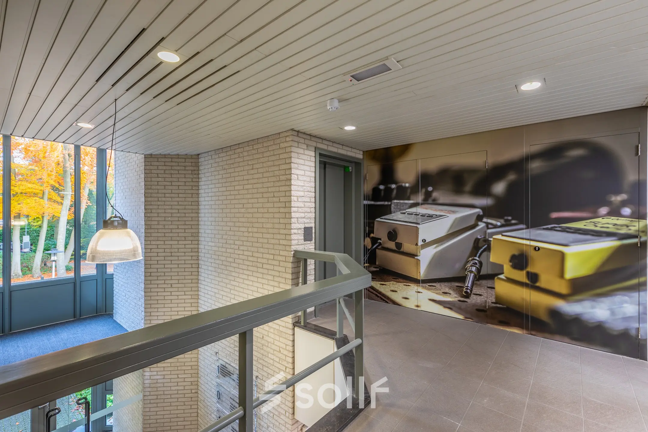 Bright office entrance at Mozartlaan 27, Hilversum, ideal for office space rental, with urban artwork on the wall.
