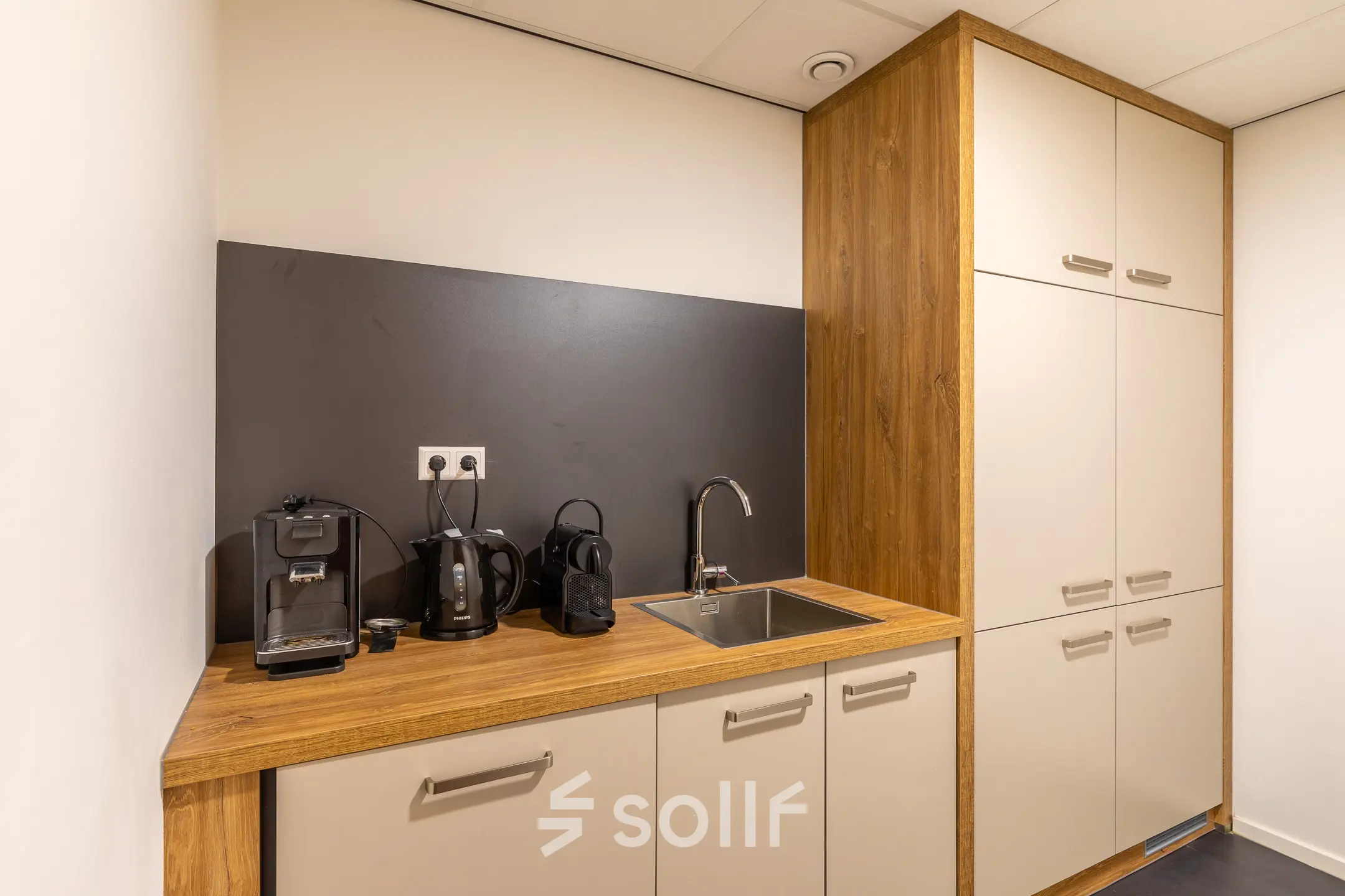 Compact office pantry featuring a sink and coffee machines, available for office space rental at Mozartlaan 27, Hilversum.