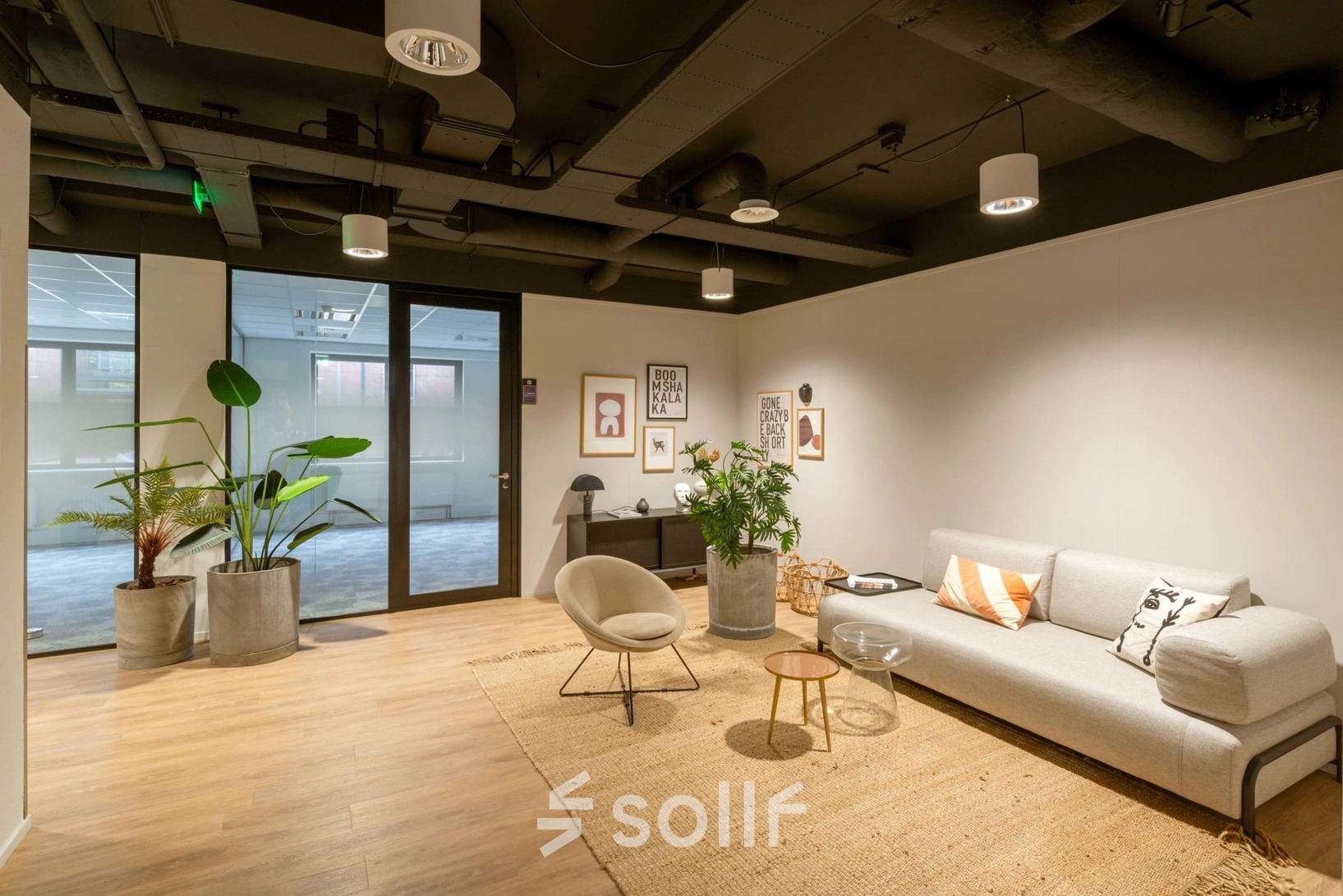 Stylish office space rental at Olympia 1, Hilversum with modern furnishings, a cozy seating area, and vibrant plants under soft lighting.