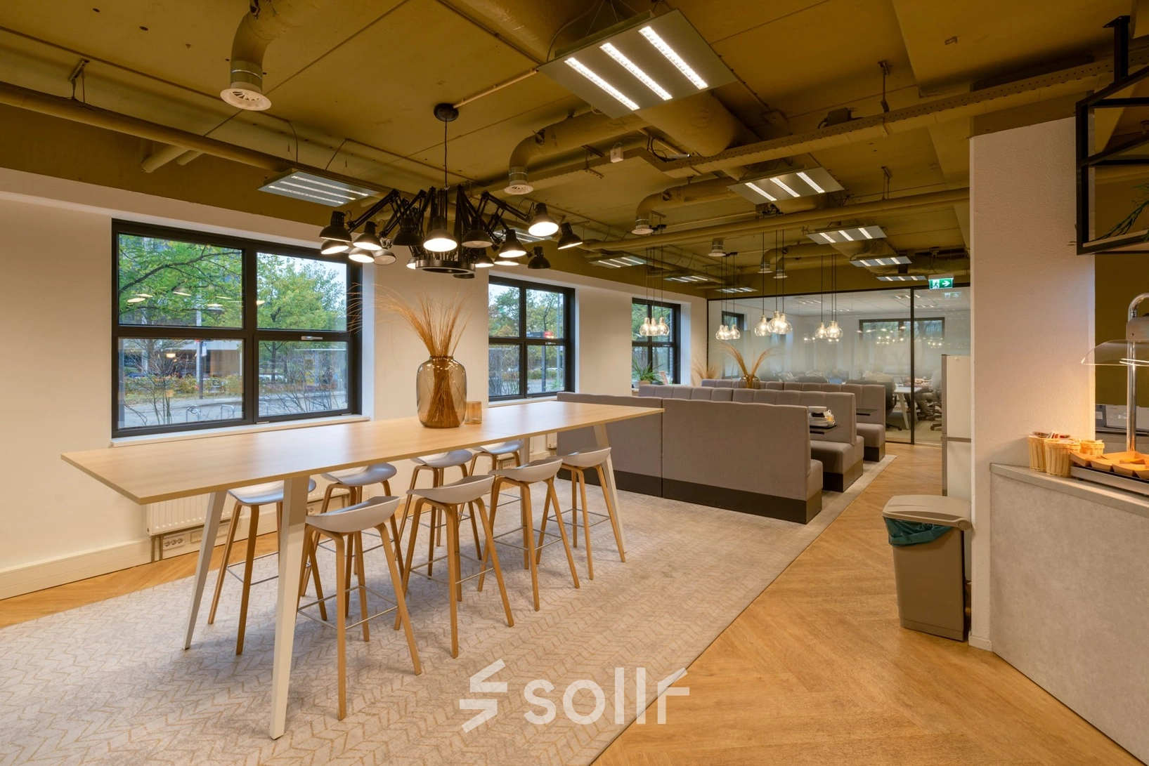 Bright, furnished office space at Olympia 1, Hilversum, with modern seating, ambient lighting, and large windows, ideal for office space rental.