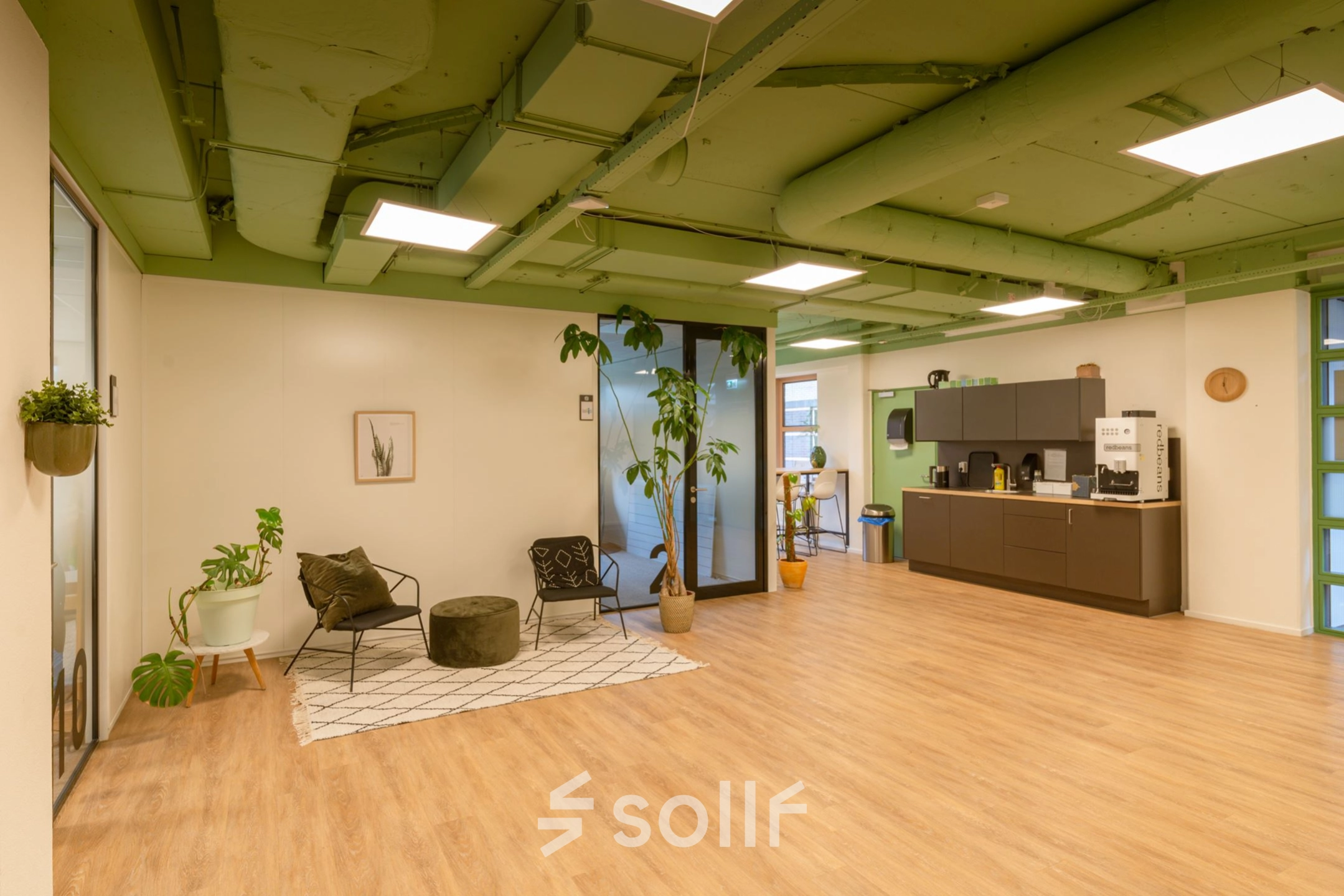 Furnished office space at Olympia 1 in Hilversum featuring a lounge area with chairs and plants, ideal for office space rental.