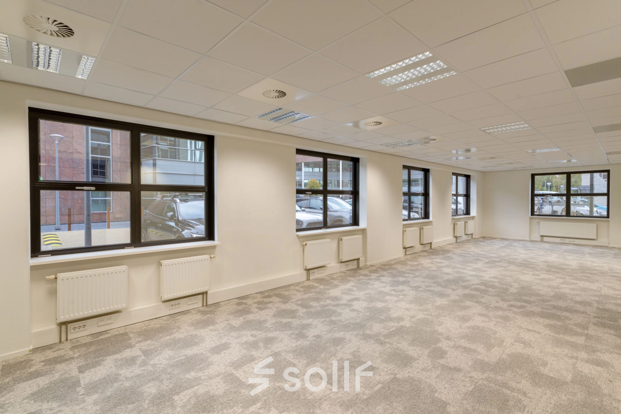 Bright and spacious office to rent at Olympia 1, Hilversum, featuring large windows and a modern carpet, ideal for your office space rental needs.