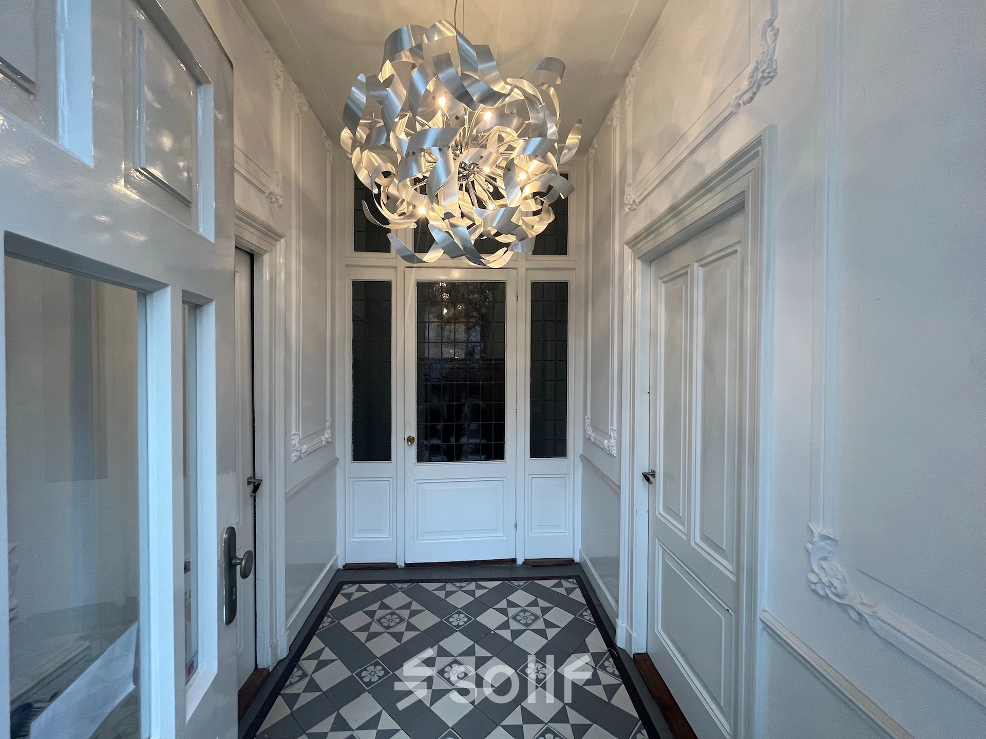 Elegant entrance area at Oude Enghweg 8, Hilversum, ideal for those seeking office space rental with stylish tiles and a unique chandelier.