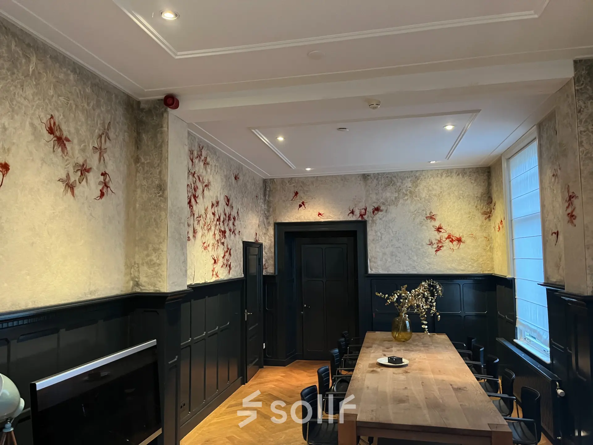 Charming office space with elegant wood paneling and decorative wall accents at Oude Enghweg 8, Hilversum. Ideal for office space rental with natural light and a large meeting table perfect for collaboration.