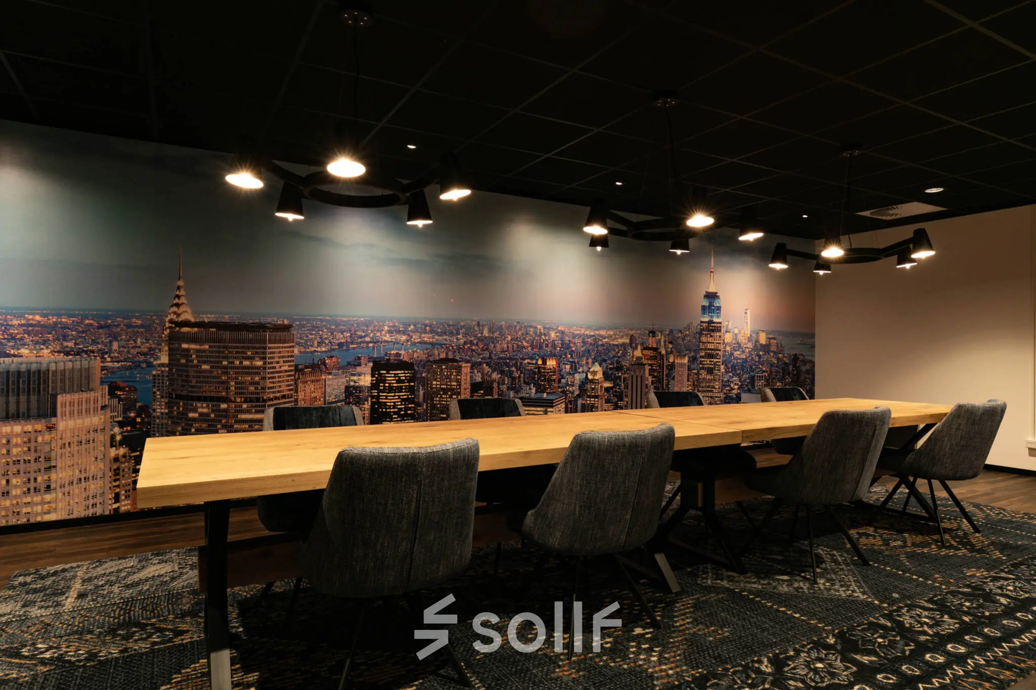 Modern conference room at Steijnlaan 16, Hilversum, featuring a large wooden table and cityscape wall mural, ideal for office space rental.