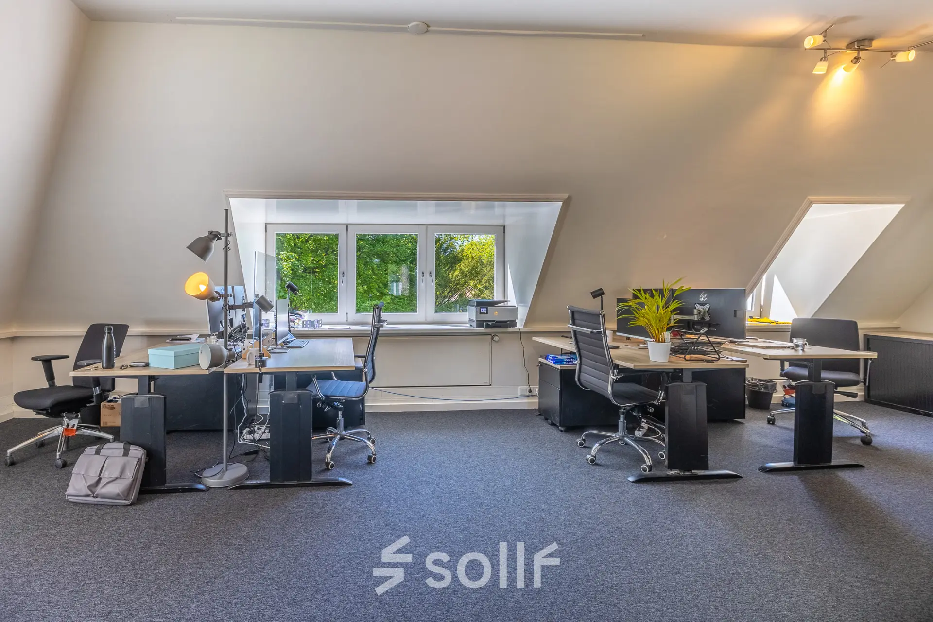 Bright office space at Utrechtseweg 47, Hilversum with modern desks and chairs, ideal for office space rental. Large windows provide natural light.
