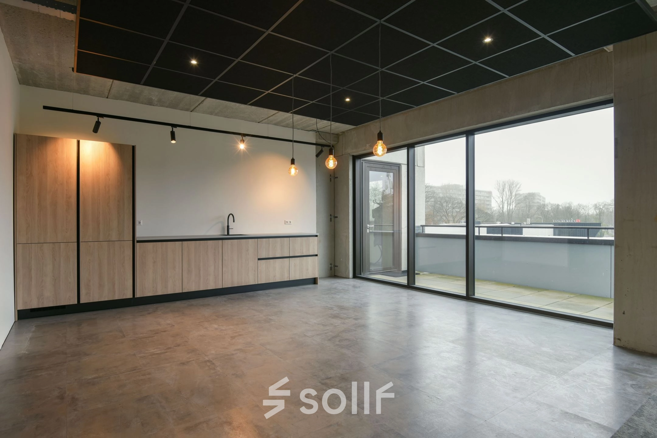 Modern office space at Zuiderloswal 55, Hilversum featuring large windows and a minimalist kitchenette, perfect for office space rental.