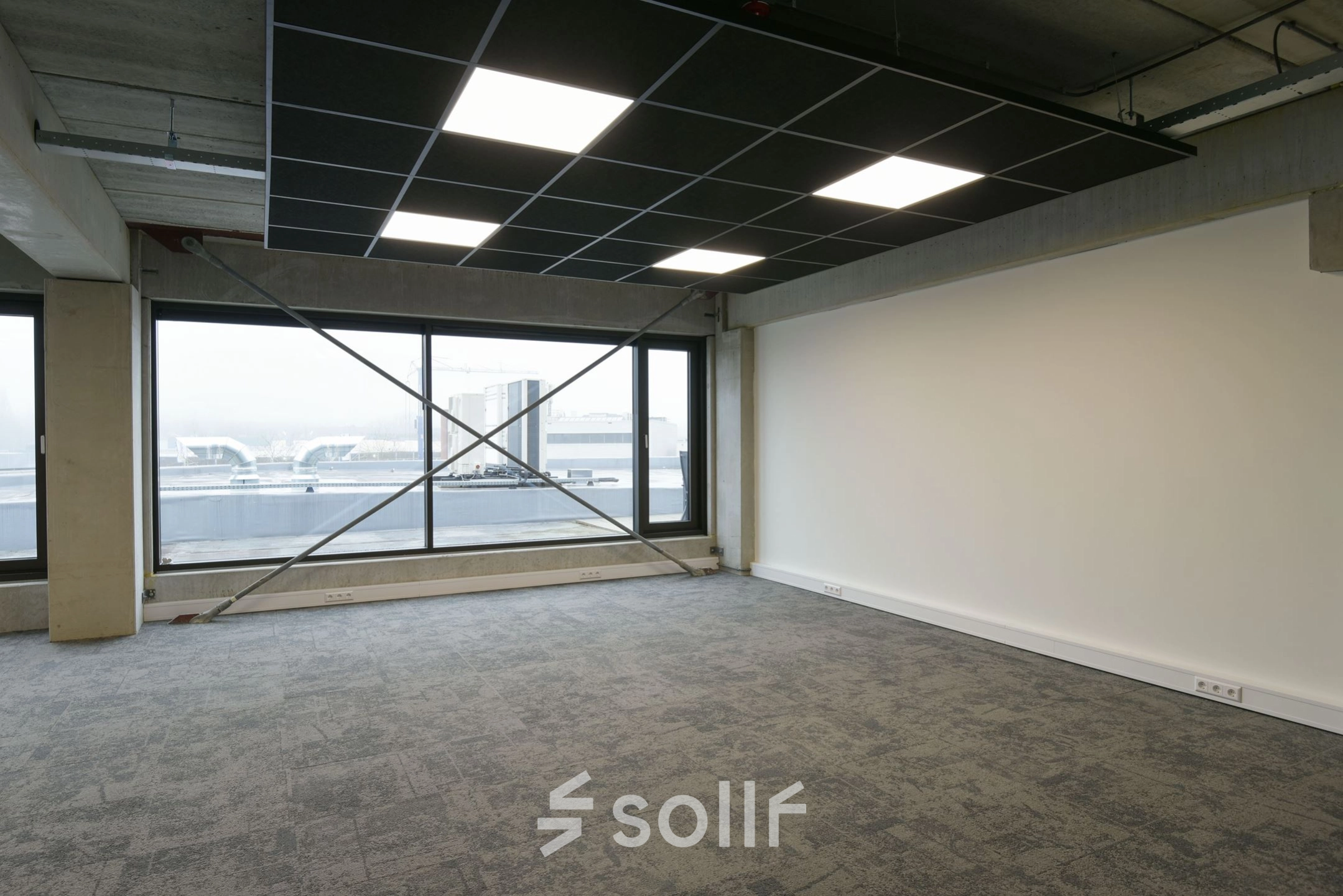 Spacious office for rent at Zuiderloswal 55, Hilversum, featuring large windows and modern carpeting, perfect for an adaptable office space rental.