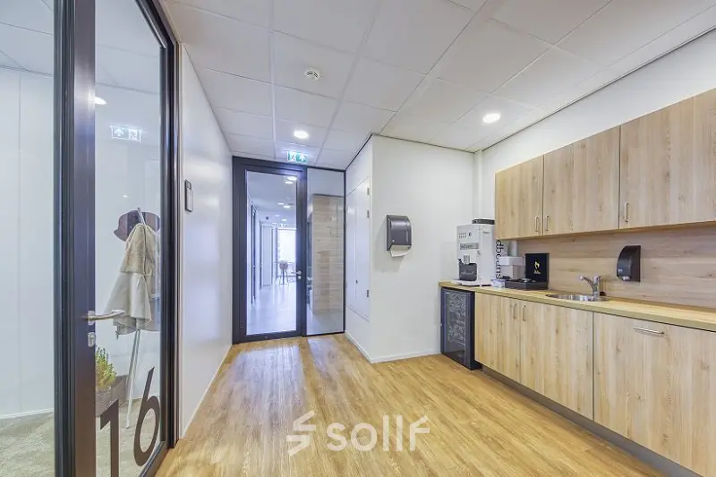 Spacious office pantry at Polarisavenue 130-150, Hoofddorp features wood flooring, cabinets, sink, and coffee machine, ideal for office space rental.