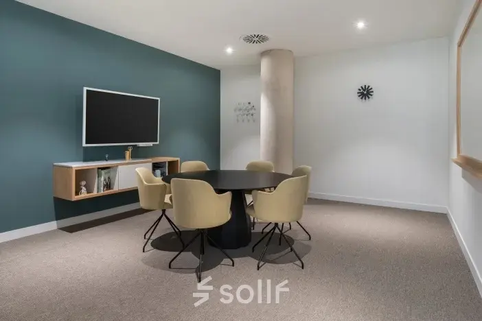 Modern office space for rent at Siriusdreef 17, Hoofddorp, featuring a sleek meeting area with a round table and minimalist decor.