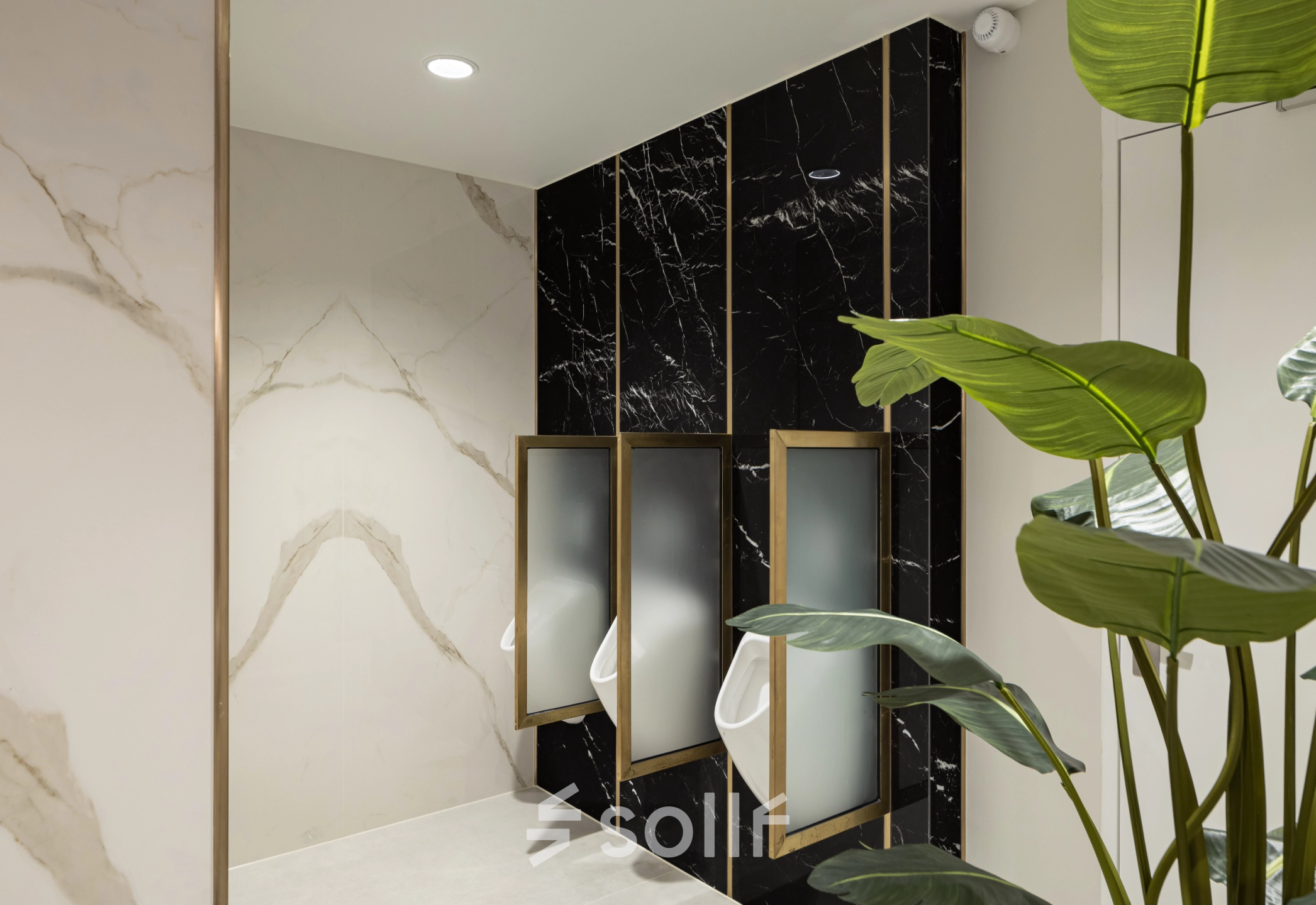 Modern restroom with elegant black marble partitions and green plant accents, located at Siriusdreef 60 in Hoofddorp, available for office space rental.