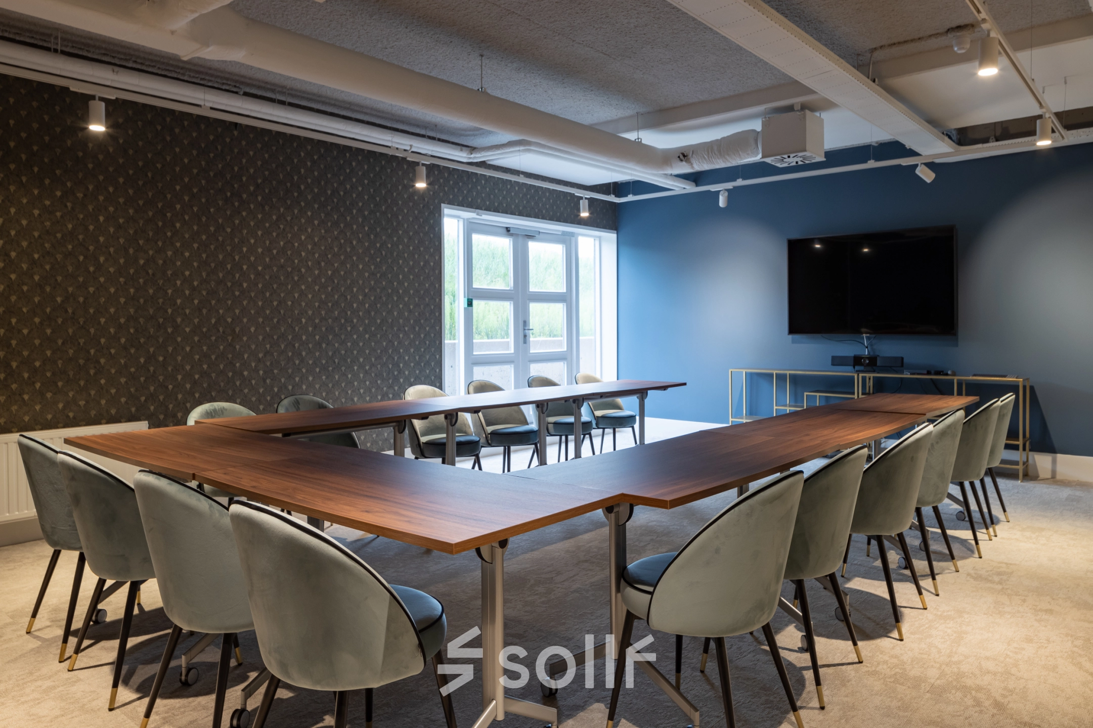 Modern conference room at Siriusdreef 60, Hoofddorp, featuring a large U-shaped table and comfortable chairs, perfect for office space rental or meetings. The room is equipped with a TV and ample natural light.