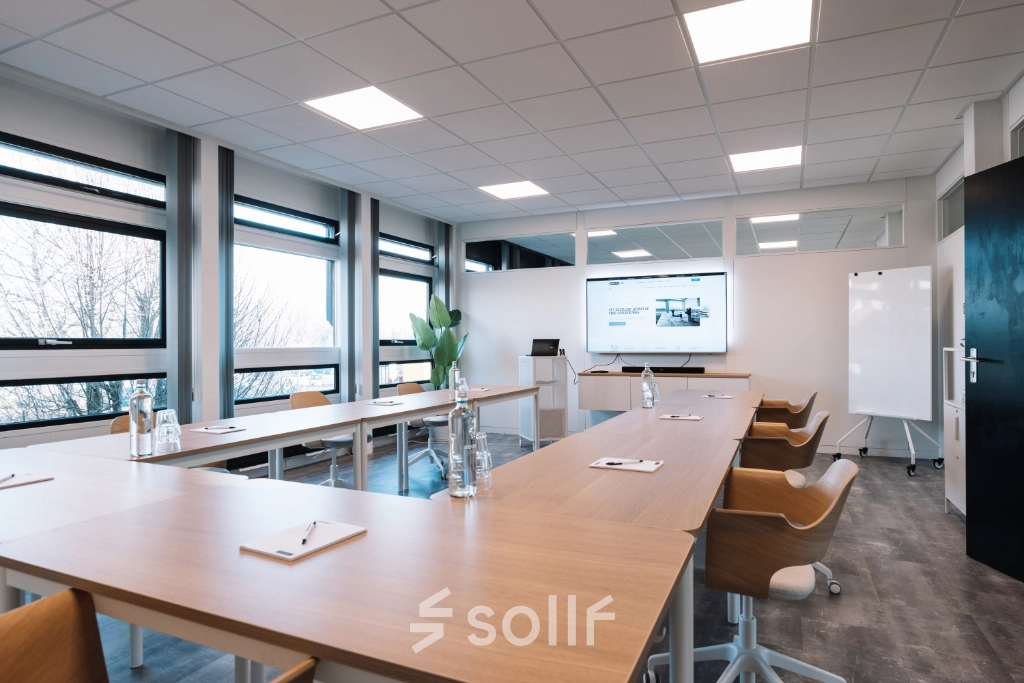 Modern office space rental in Hoogeveen with furnished conference room at De Vos van Steenwijklaan 75, featuring large windows, ample seating, and a presentation setup.