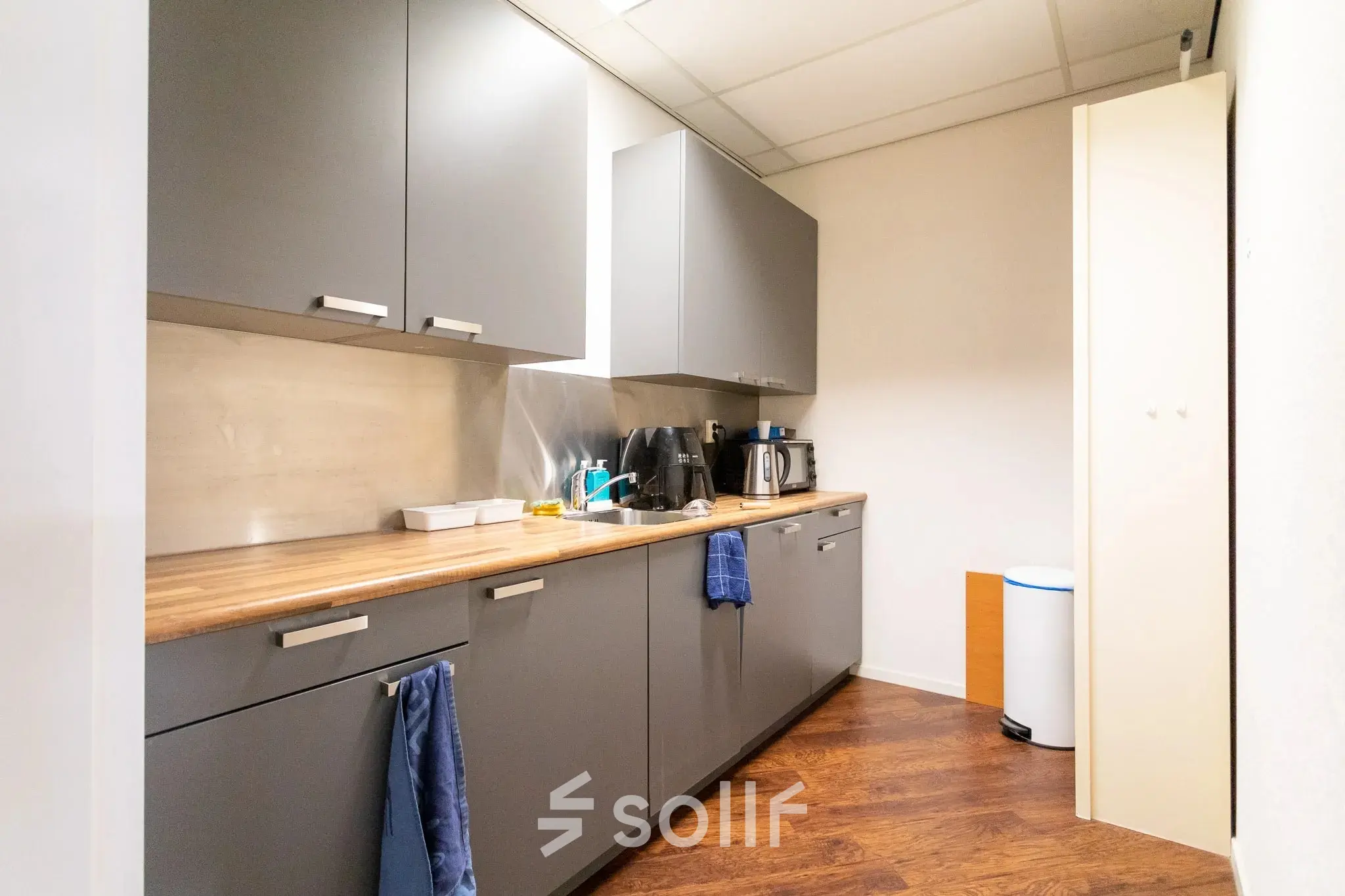 Cozy pantry space at Sandtlaan 36, Katwijk, equipped with storage cabinets, a coffee maker, and a dishwasher, perfect for office space rental.