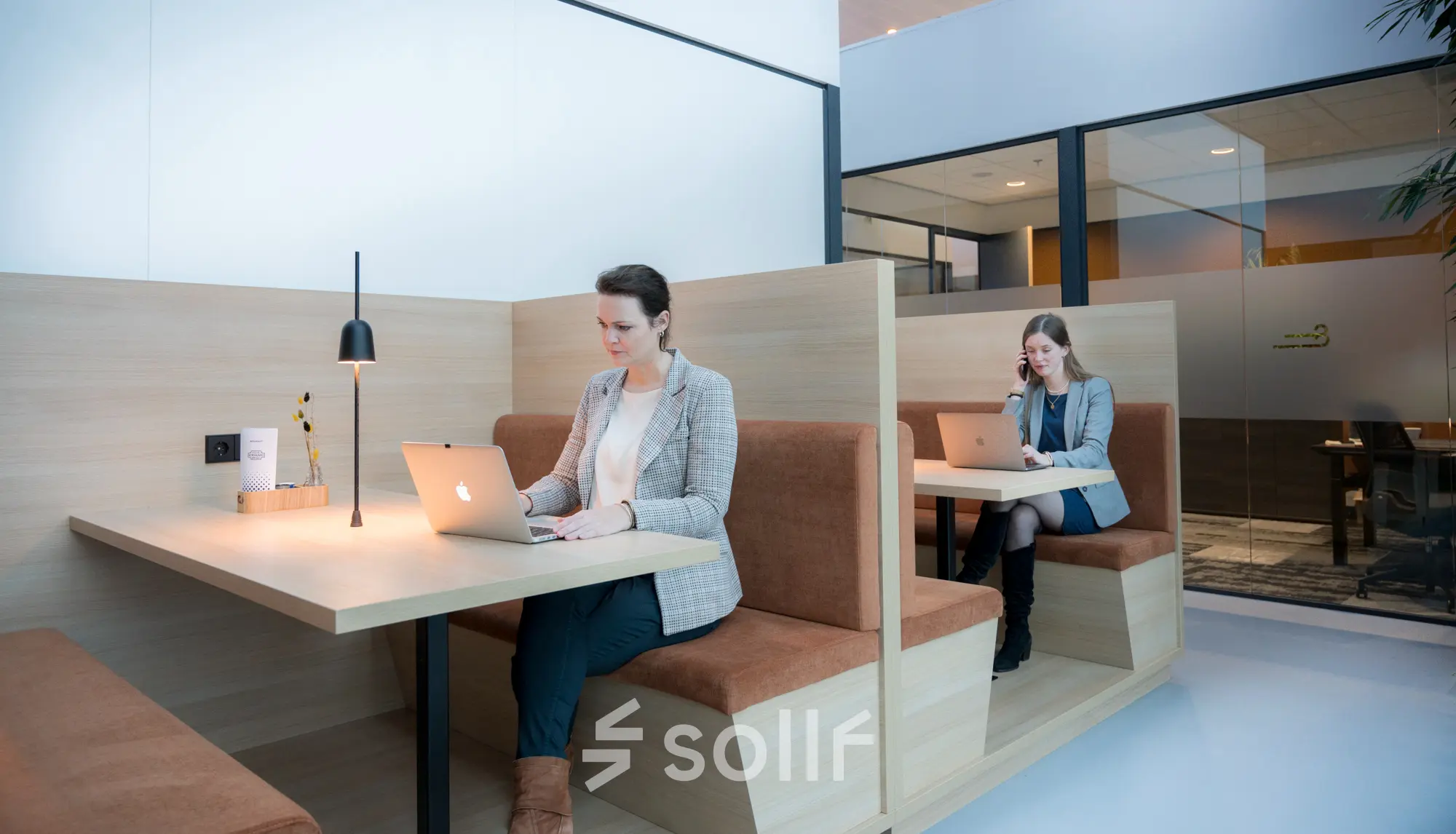 Modern office space at Bargelaan 200, Leiden, featuring booth-style seating with professionals working on laptops, ideal for office space rental.