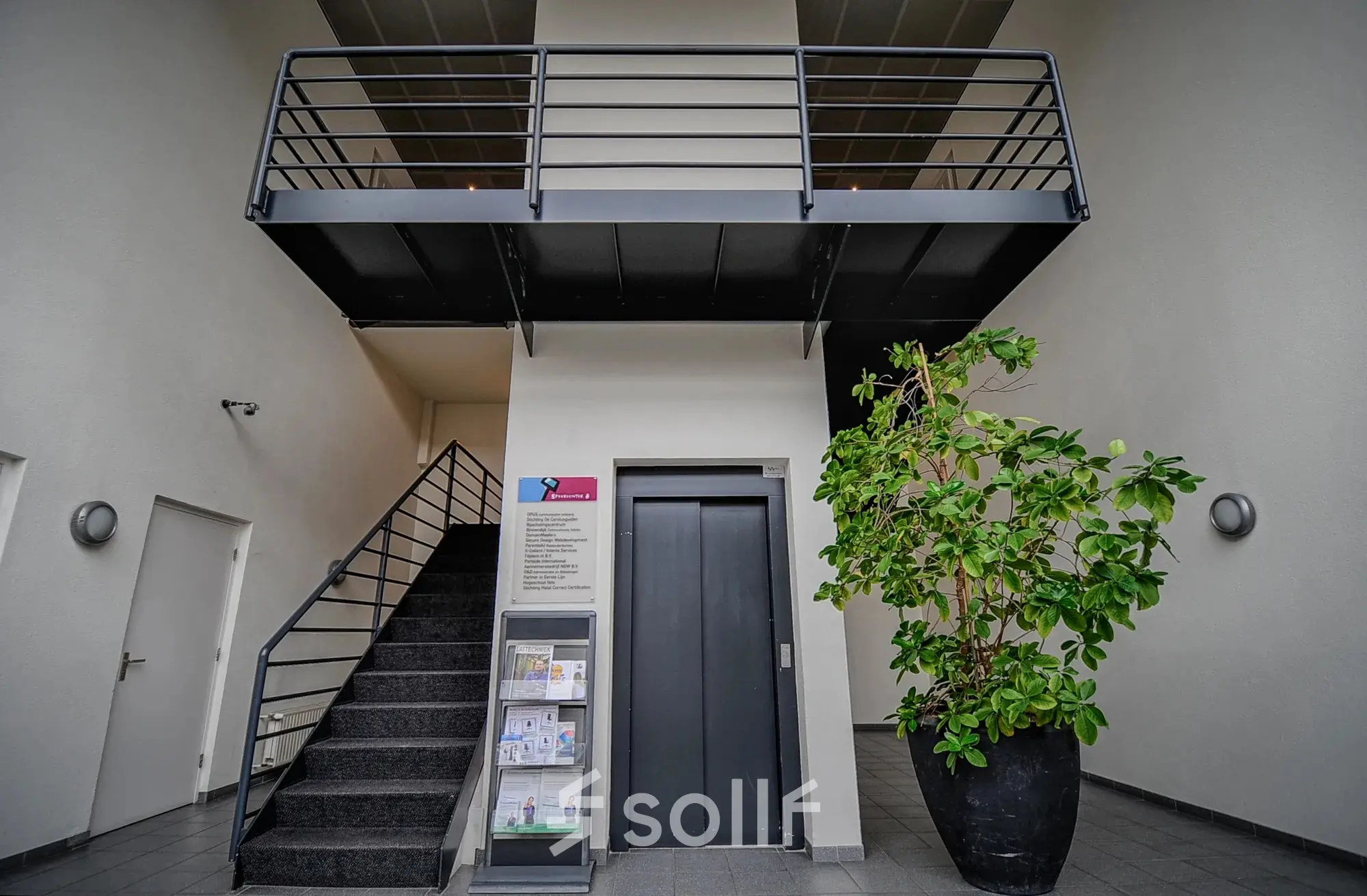 Spacious office entrance at Fruitweg 22, Leiden, available for rent. Features a modern interior with a staircase and elevator access.