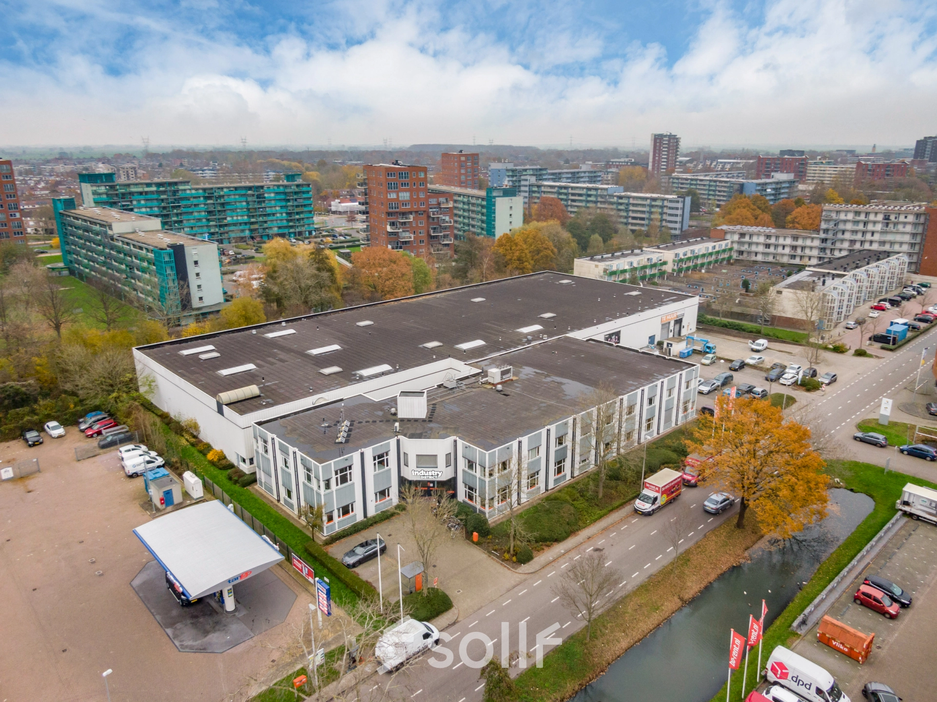 A spacious office building located at Touwbaan 38, Leiderdorp, suitable for office space rental. The white, two-story structure is set in an industrial area with ample parking.