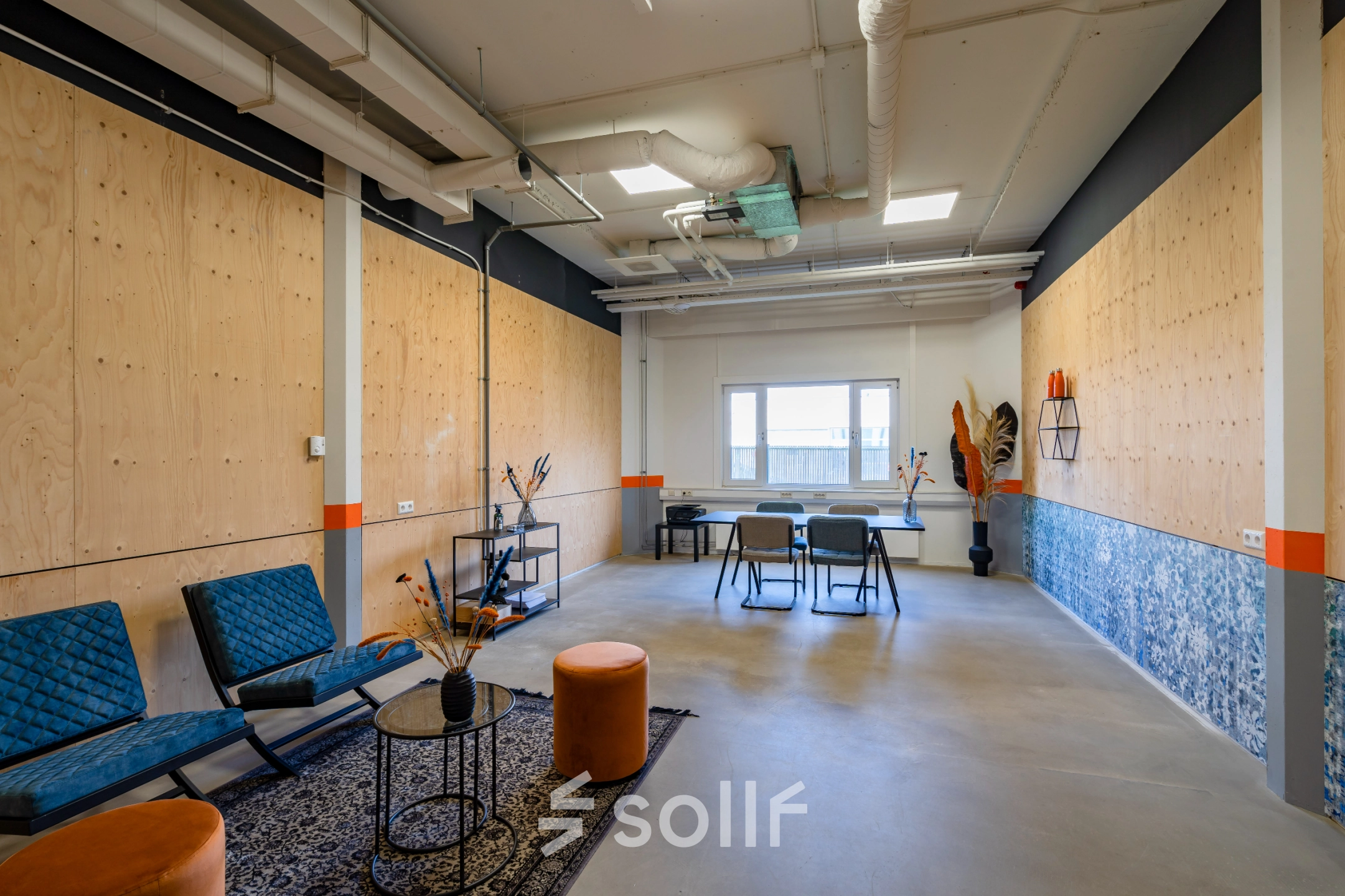 Office space rental at Touwbaan 38 in Leiderdorp featuring a modern interior with blue chairs, tables, and decorative elements, perfect for casual meetings or work sessions.
