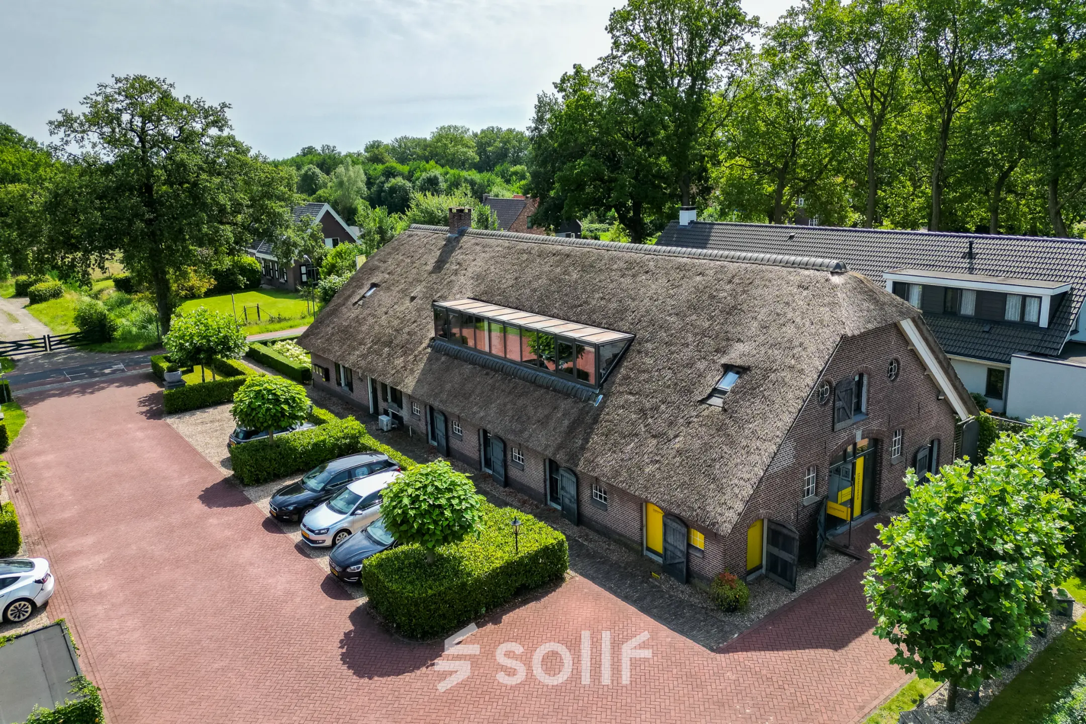 Exterior view of office space at Hamersveldseweg 120, Leusden, featuring a rustic building with a thatched roof and ample parking.