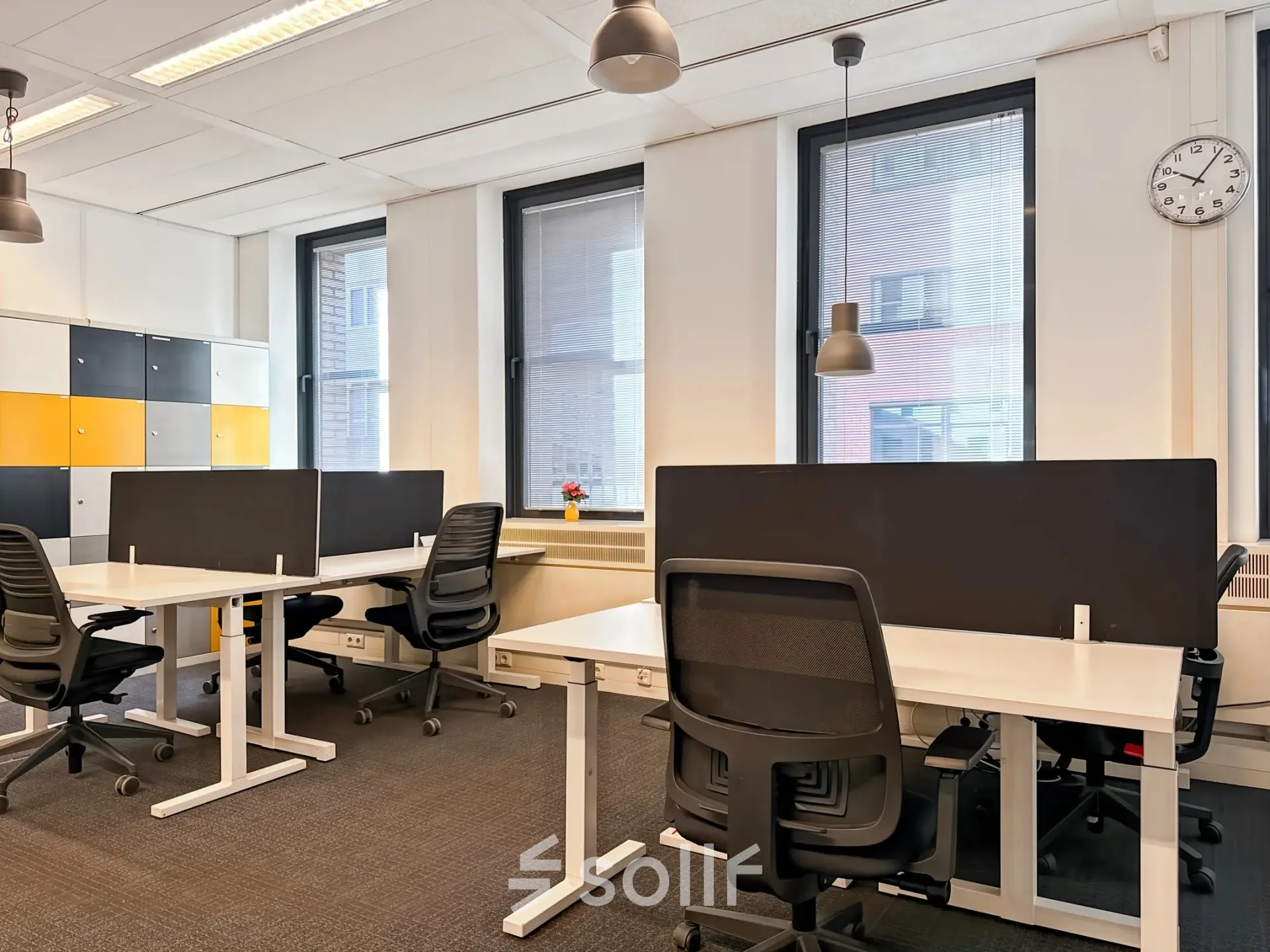 Bright office space with several desks, chairs, and dividers, ideal for those seeking office space rental at Robert Schumandomein 2, Maastricht.