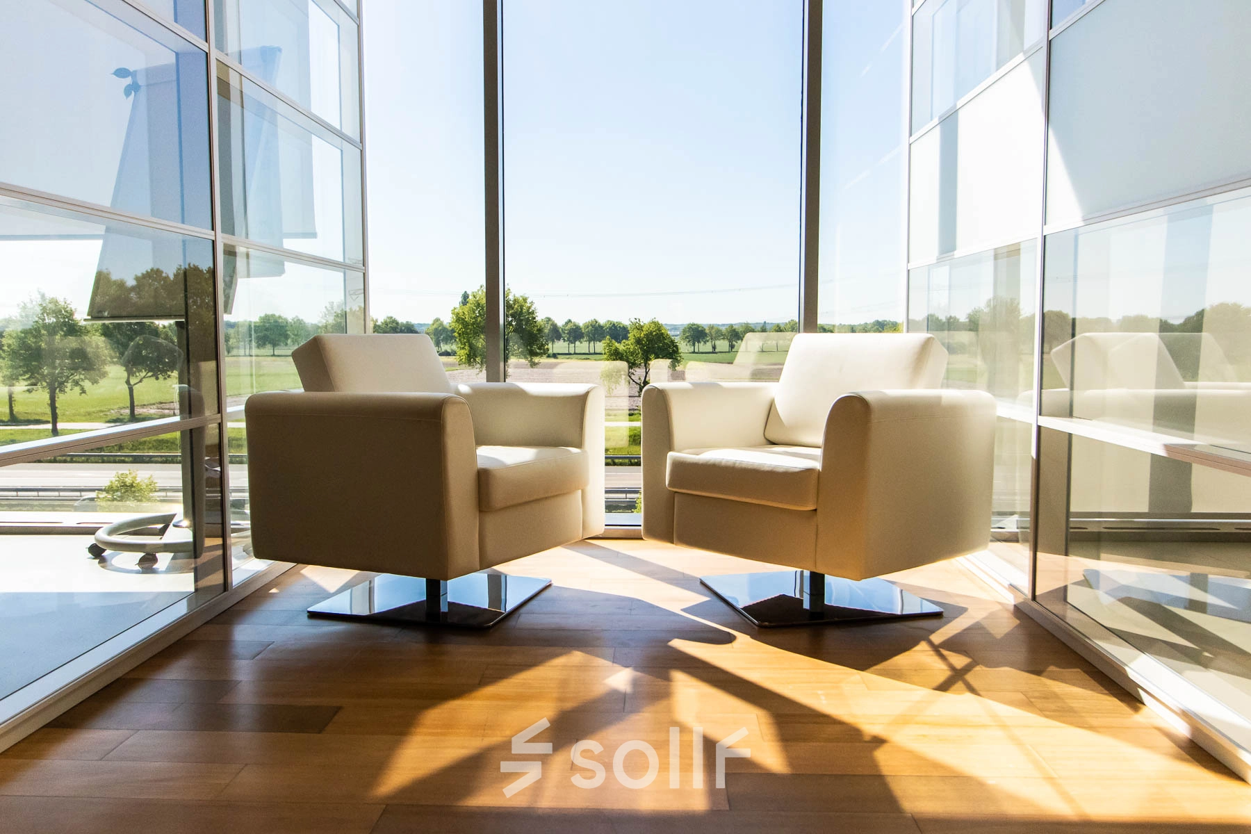 Bright office space with two modern chairs and large window view at Brieltjenspolder 28, Made, ideal for office space rental.