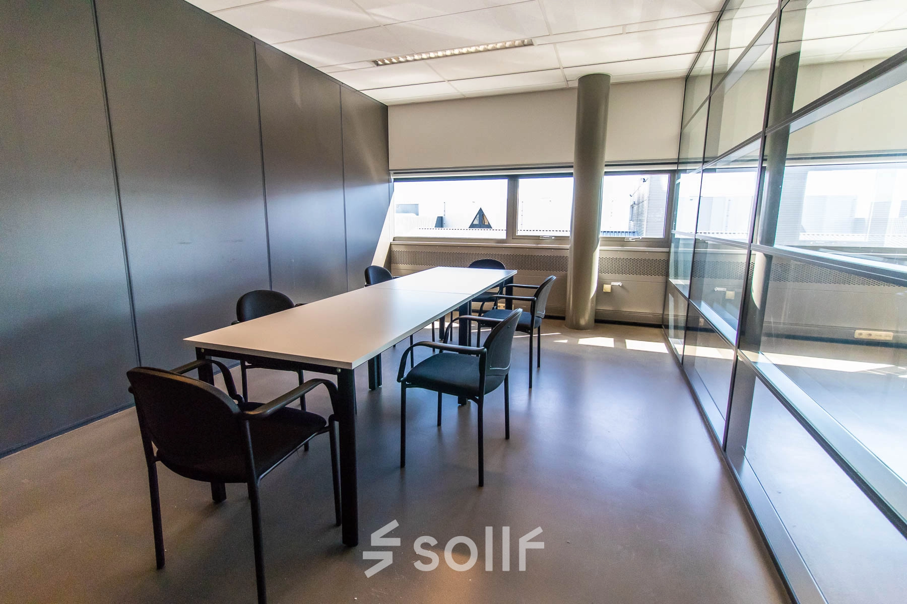 Bright, furnished office space rental in Made at Brieltjenspolder 28, featuring a meeting table and chairs with ample natural light.