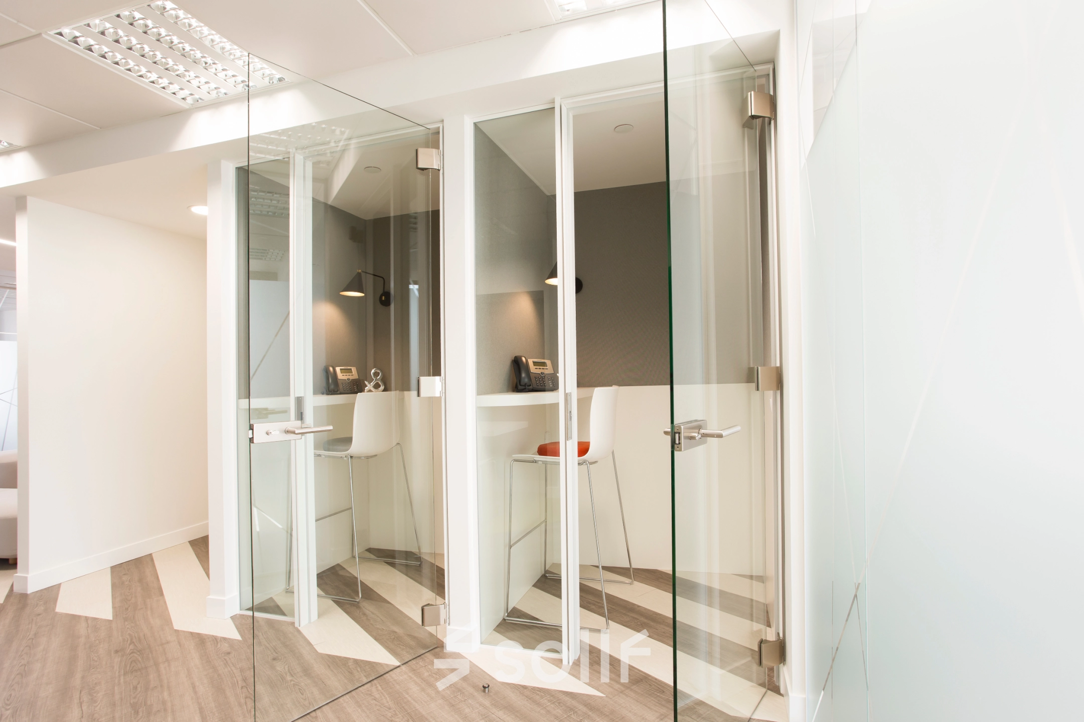Modern office space rental at Paseo de la Castellana 141 in Madrid Azca with glass partitions and contemporary furnishings.
