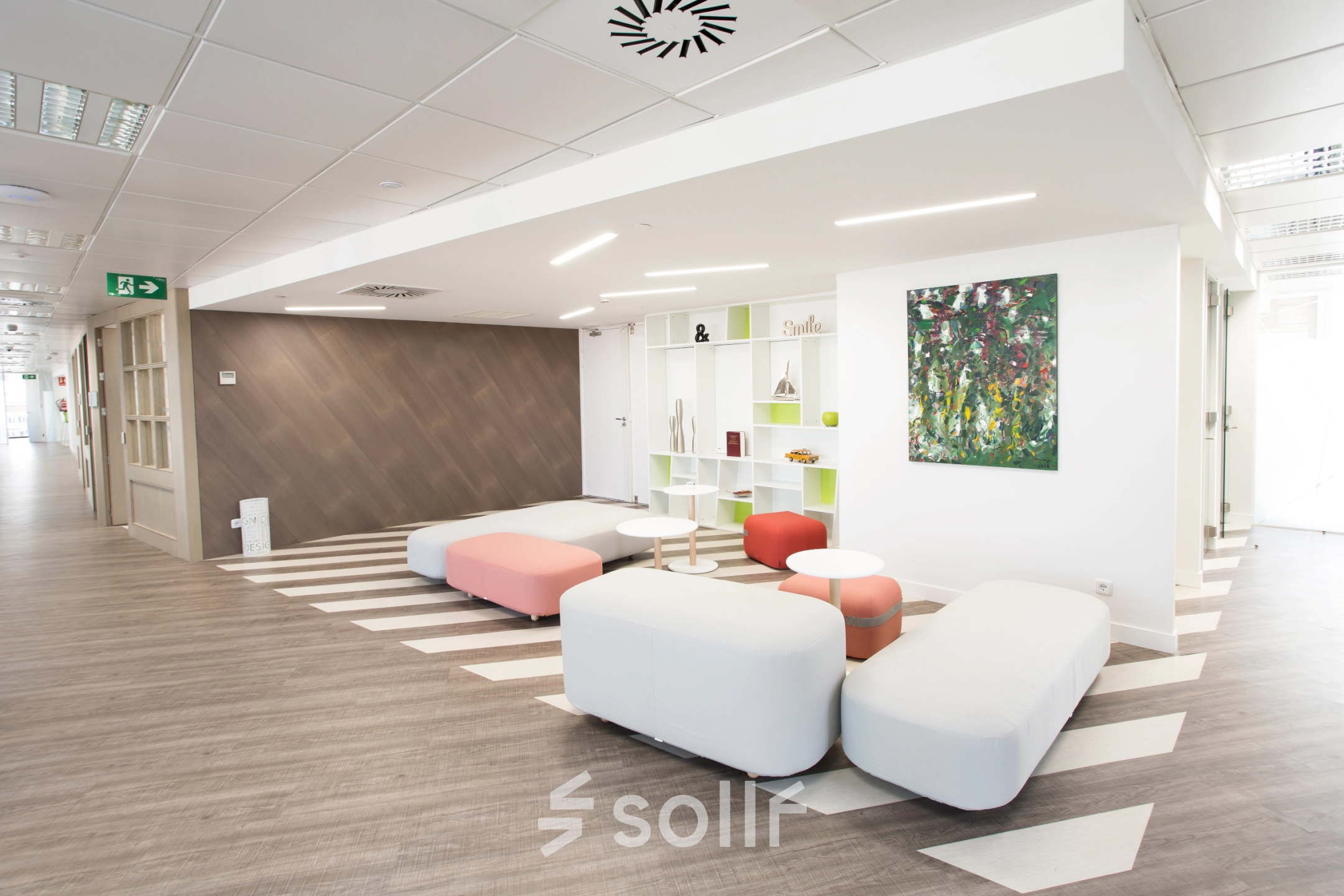 Open and inviting office area with modern seating and decorative shelving, located at Paseo de la Castellana 141, ideal for office space rental in Madrid Azca.