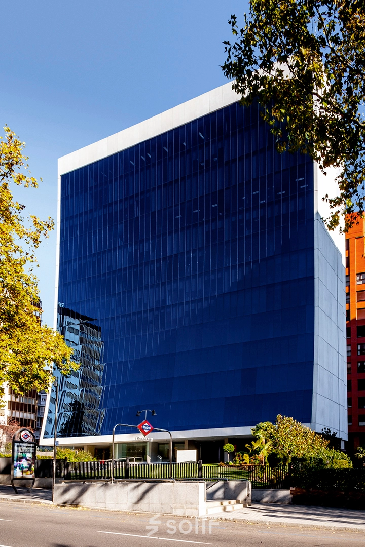 Modern office building with blue glass facade located on Paseo de la Castellana 141 in Madrid Azca, ideal for office space rental.