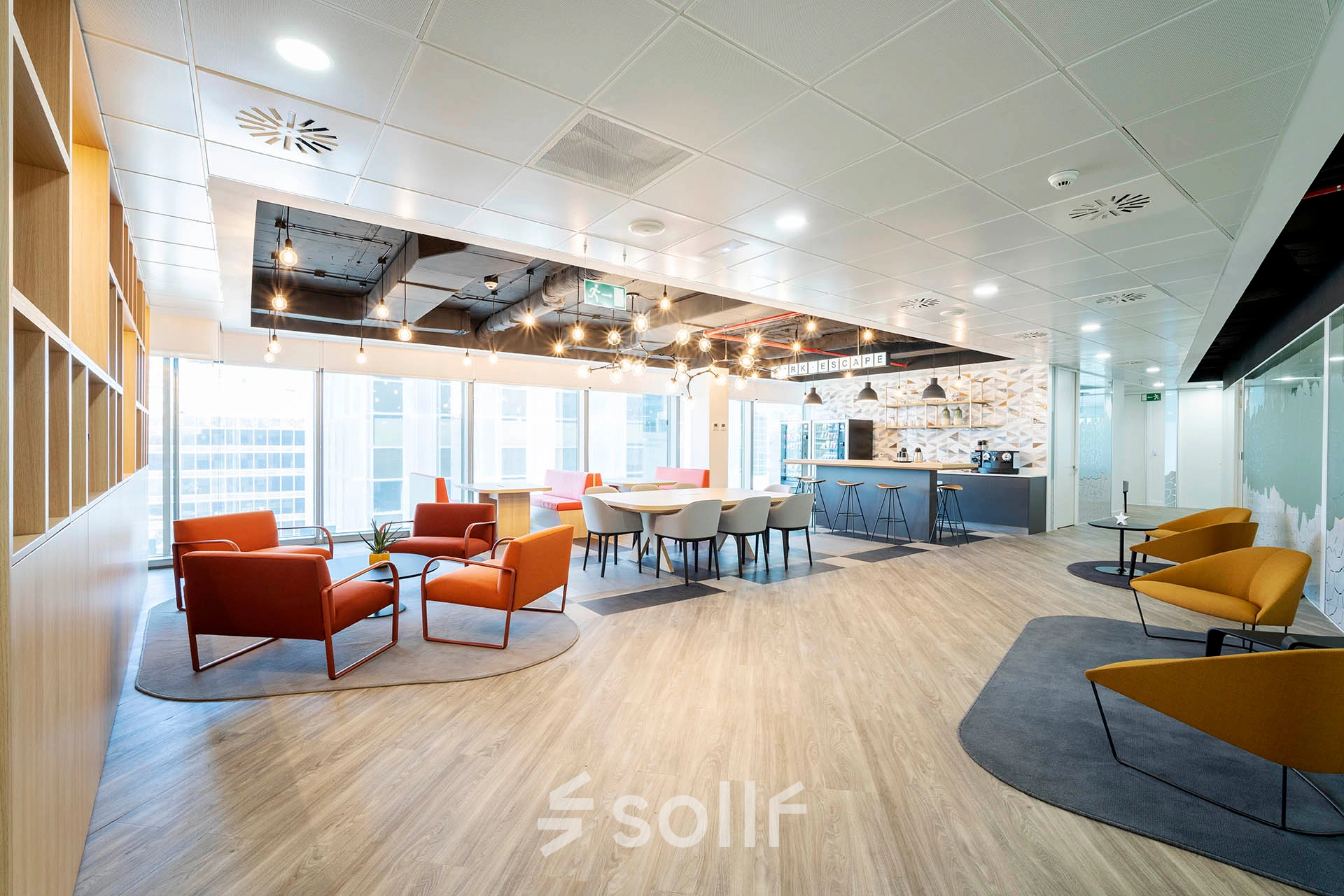 Bright, modern office space with colorful seating areas and panoramic windows, located at Paseo de la Castellana 79, ideal for rent office space in Madrid Azca.