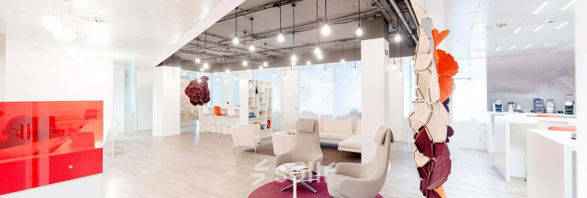 Modern office space at Paseo de la Castellana 79, Madrid Azca, with contemporary furnishings including lounge chairs and a sofa, ideal for office space rental.