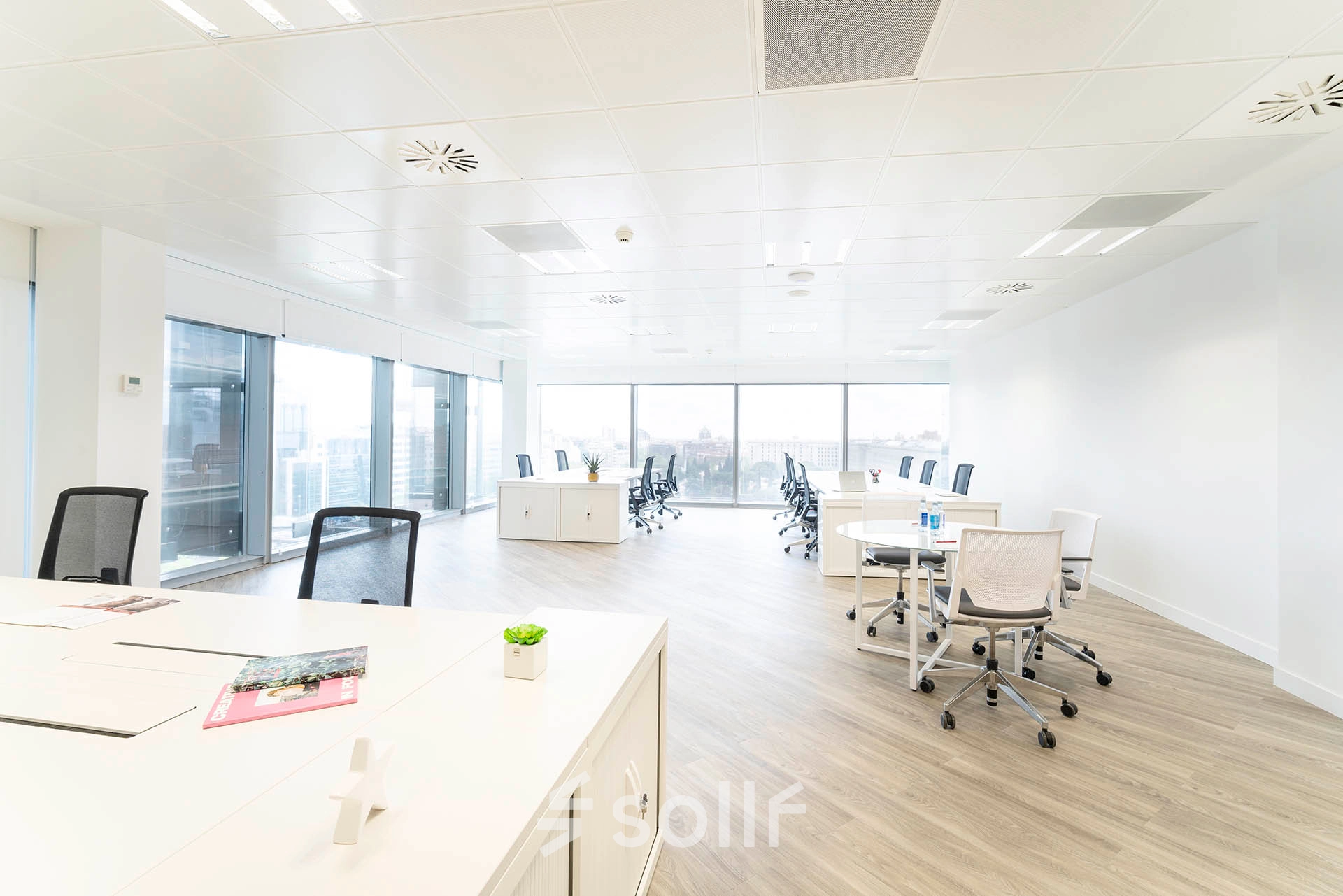 Bright and spacious office to rent in Madrid Azca with desks and chairs, featuring large windows for natural light.