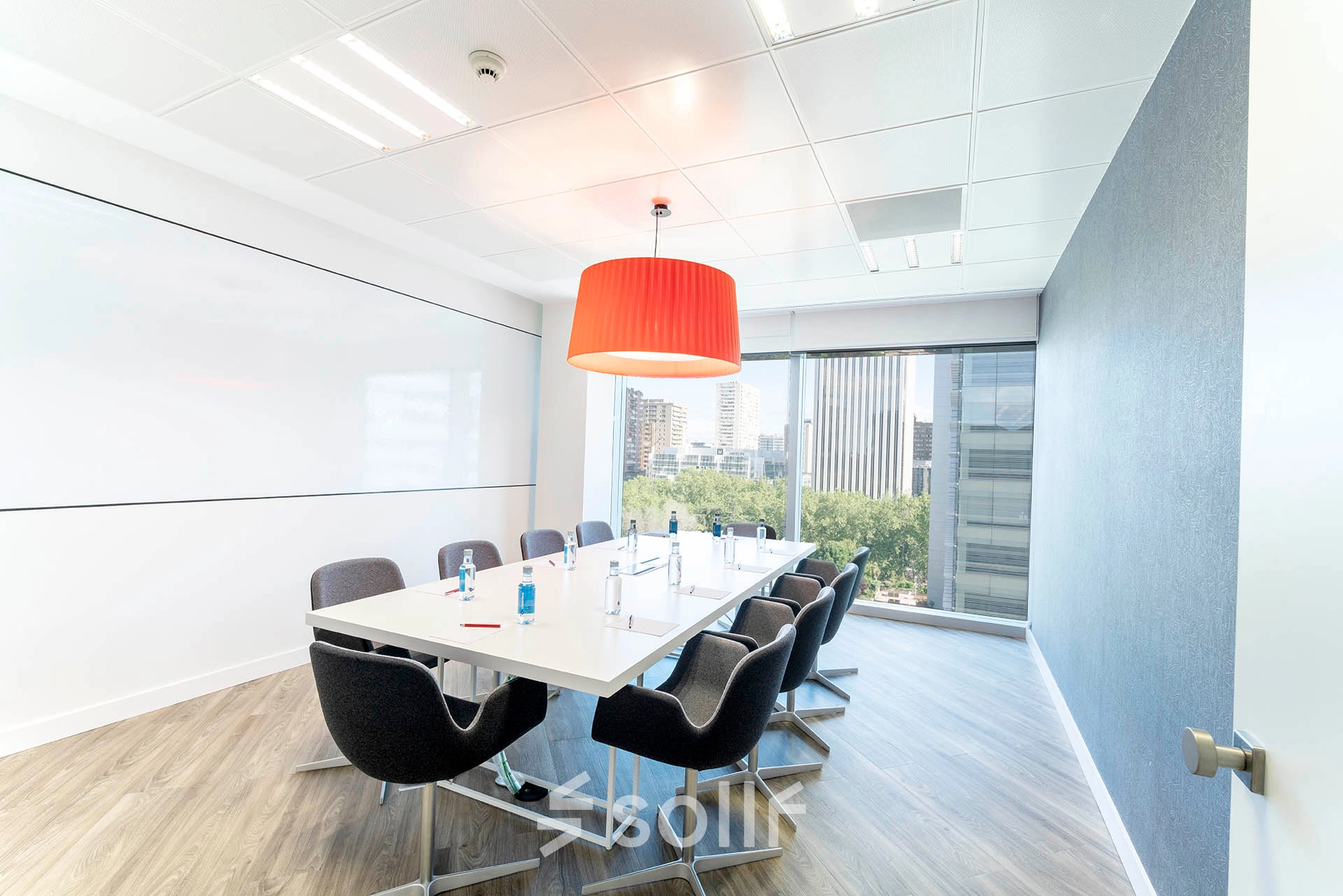 Bright office space featuring a large table with chairs, ideal for conference meetings, located in Madrid Azca. Perfect for those looking to rent office space with a view at Paseo de la Castellana 79.