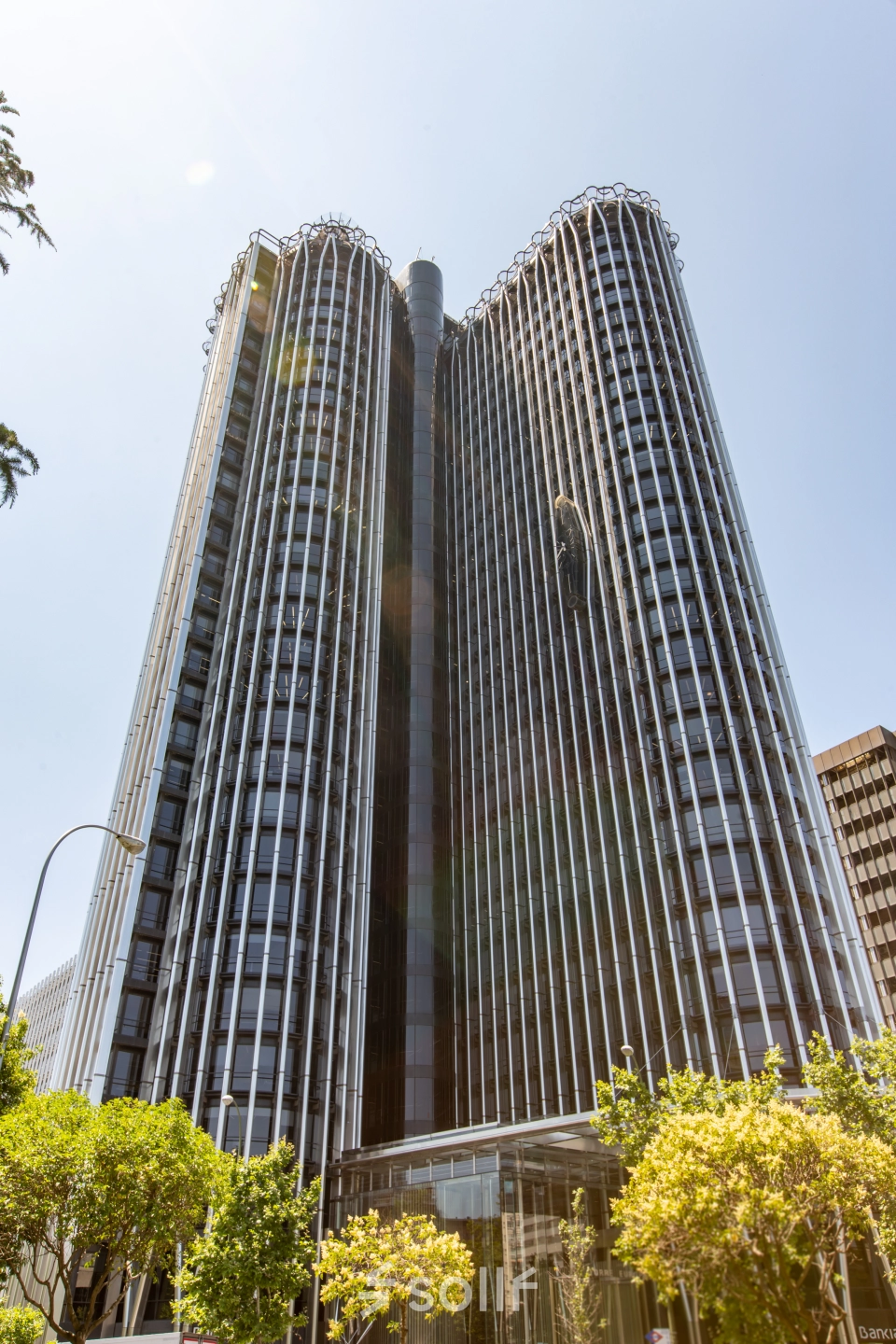 Tall modern building with unique architecture located at Paseo de la Castellana 95, Madrid Azca, ideal for office space rental.