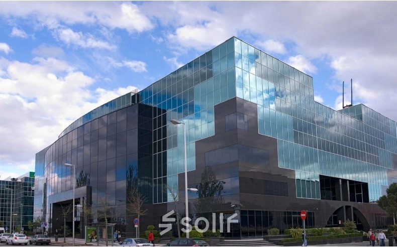 Modern office building at Avenida del Partenón 16-18 in Madrid Barajas, showcasing mirrored glass facade ideal for office space rental.