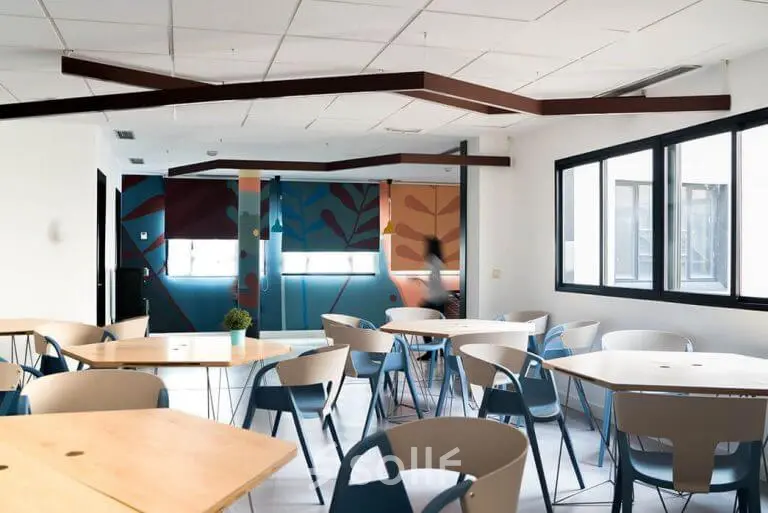 Bright office to rent in Madrid Center with modern furnishings, featuring colorful elements and ample seating, ideal for collaborative work or meetings.