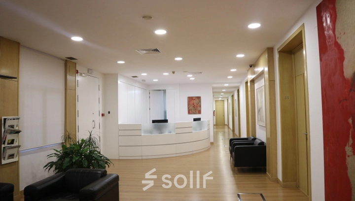 Spacious office reception area at Calle Gran Vía 6 in Madrid Center. Features a sleek front desk, seating area, and bright lighting, ideal for office space rental.