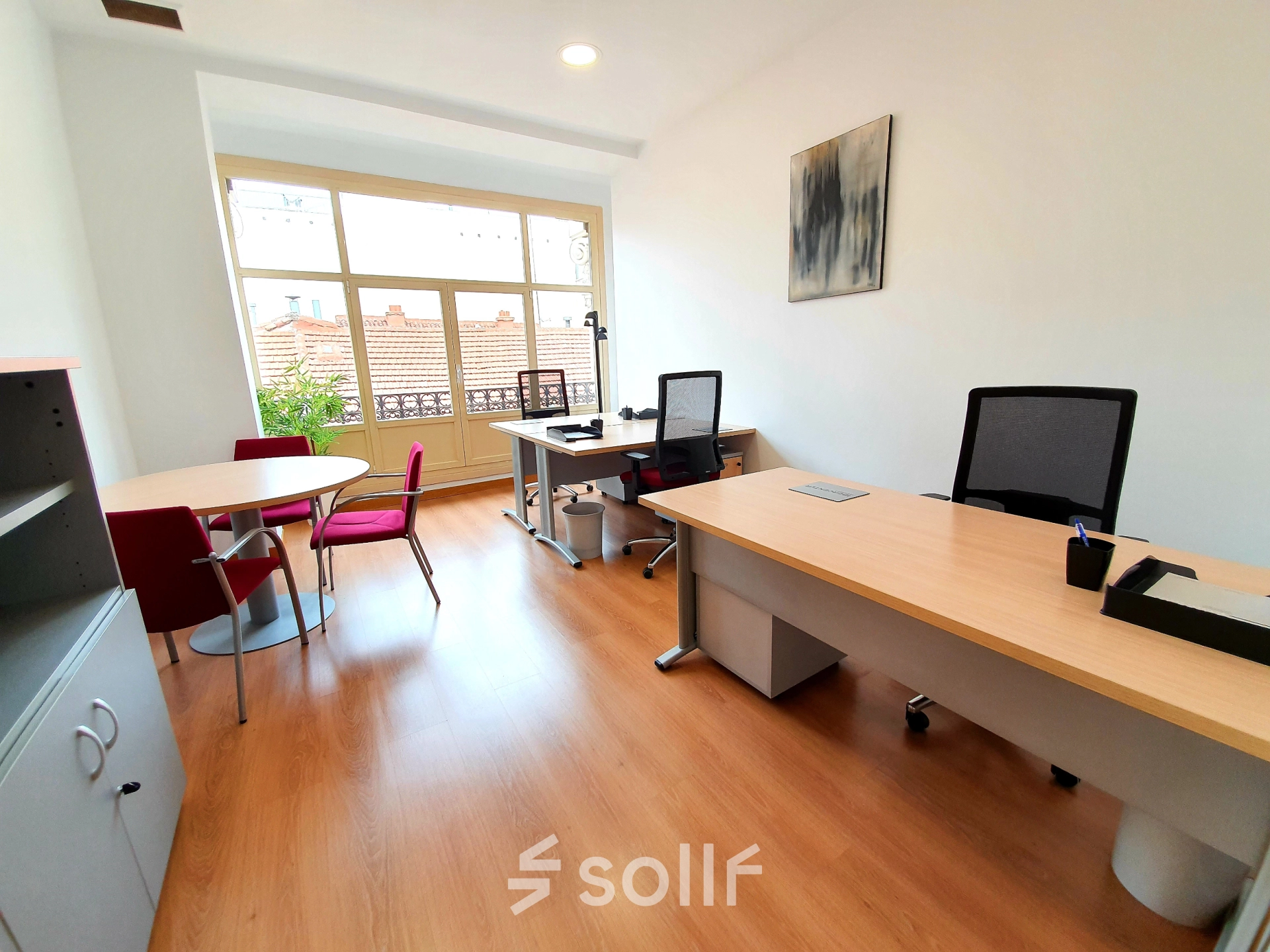 Bright office space with large windows, modern furniture, and two desks at Calle Gran Vía 6, perfect for rent office space in Madrid Center.