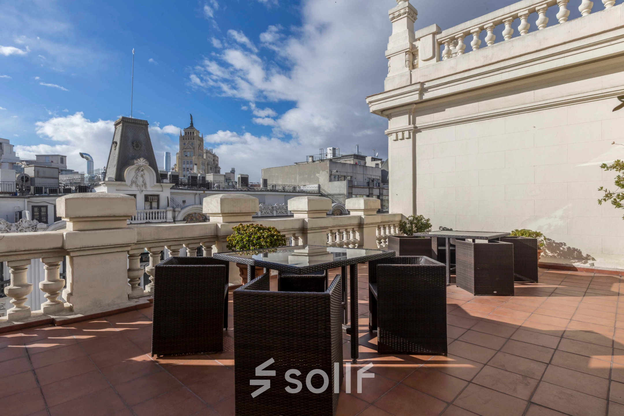 Outdoor terrace with wicker furniture on Calle Gran Vía 6, perfect for breaks during office space rental in Madrid Center.