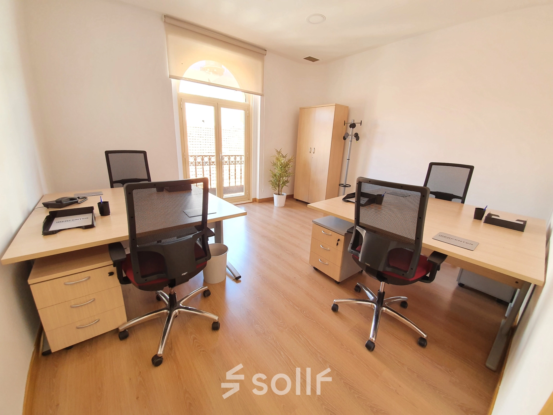 Furnished office space rental on Calle Gran Vía 6 in Madrid Center featuring desks and chairs with sunlight filtering through large windows.