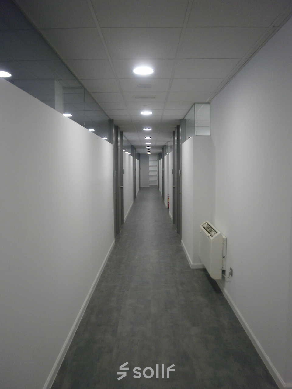 Long corridor in an office building at Plaza Santa María Soledad Torres Acosta 1, in Madrid Center, ideal for office space rental. Bright, with clean lines and modern lighting suitable for professional use.